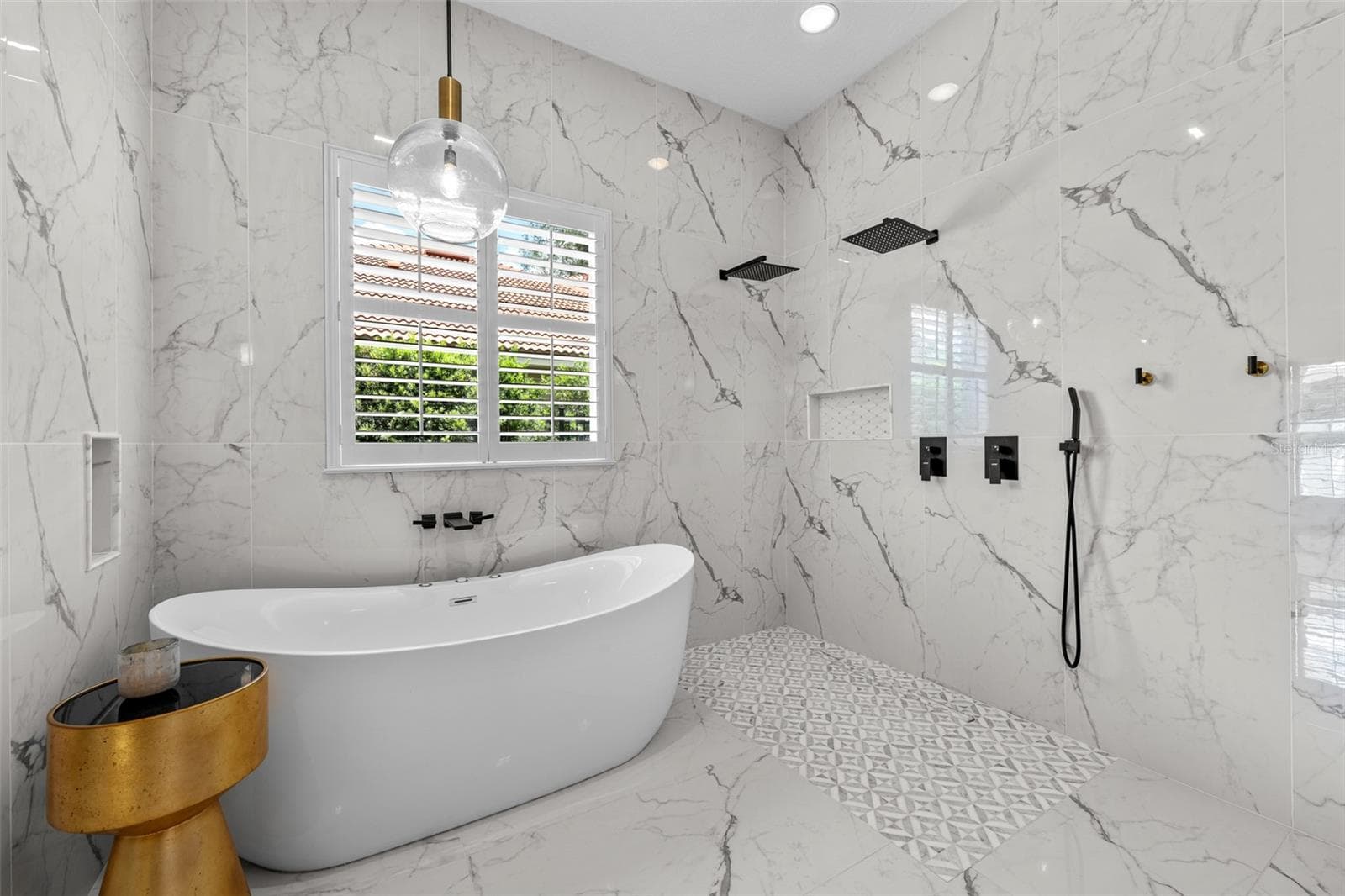 Primary Bathroom - Wet-room layout with freestanding tub, dual rain showerheads, handheld sprayer, and patterned mosaic tile floor. - 1921 FLORESTA VIEW DR, TAMPA