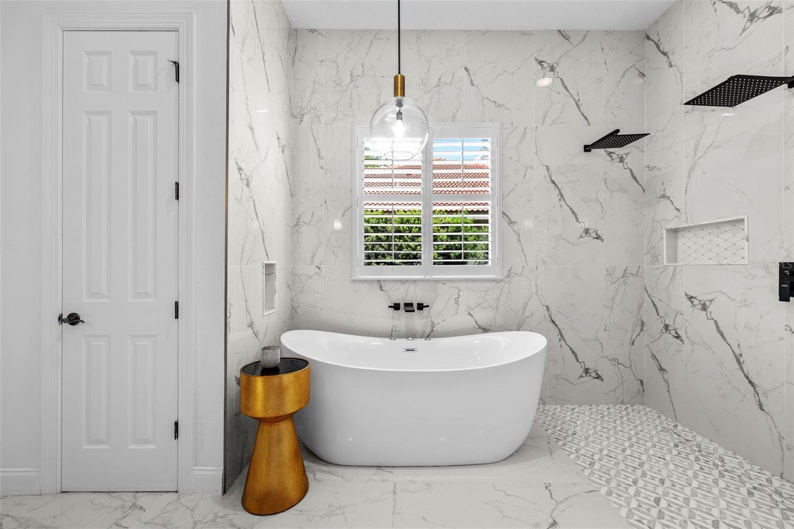 Freestanding tub inside the walk-in shower with window and plantation shutters. - 1921 FLORESTA VIEW DR, TAMPA