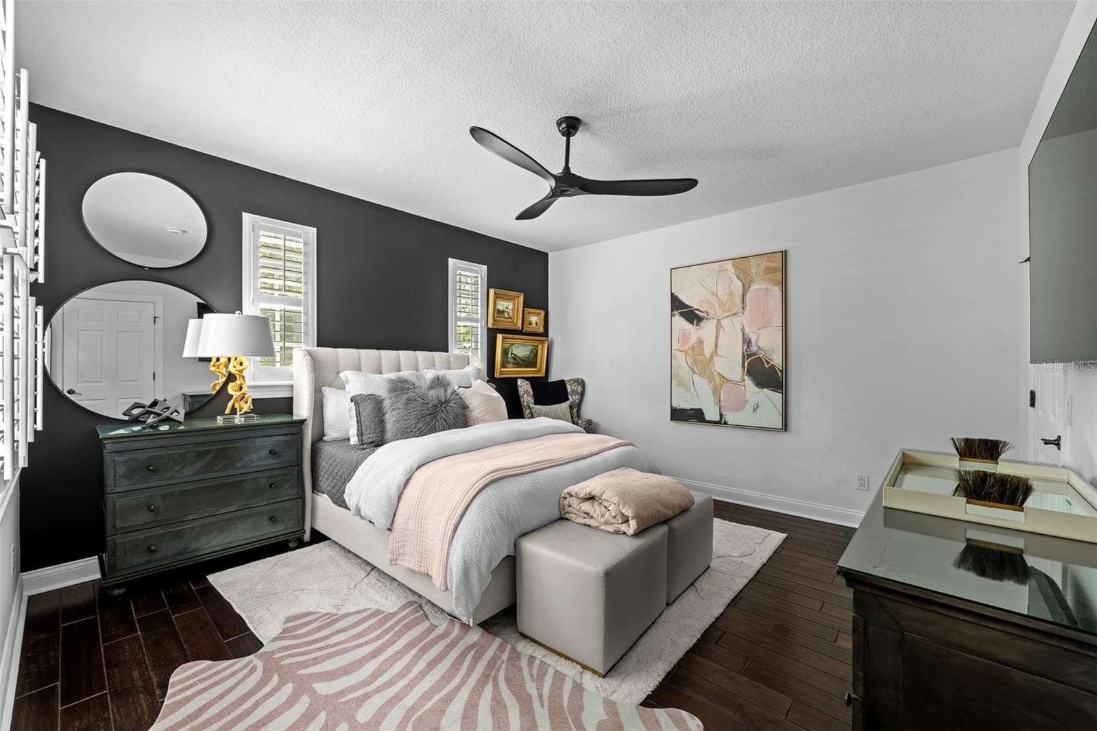 Dark wood flooring, accent wall, and windows with plantation shutters. - 1921 FLORESTA VIEW DR, TAMPA
