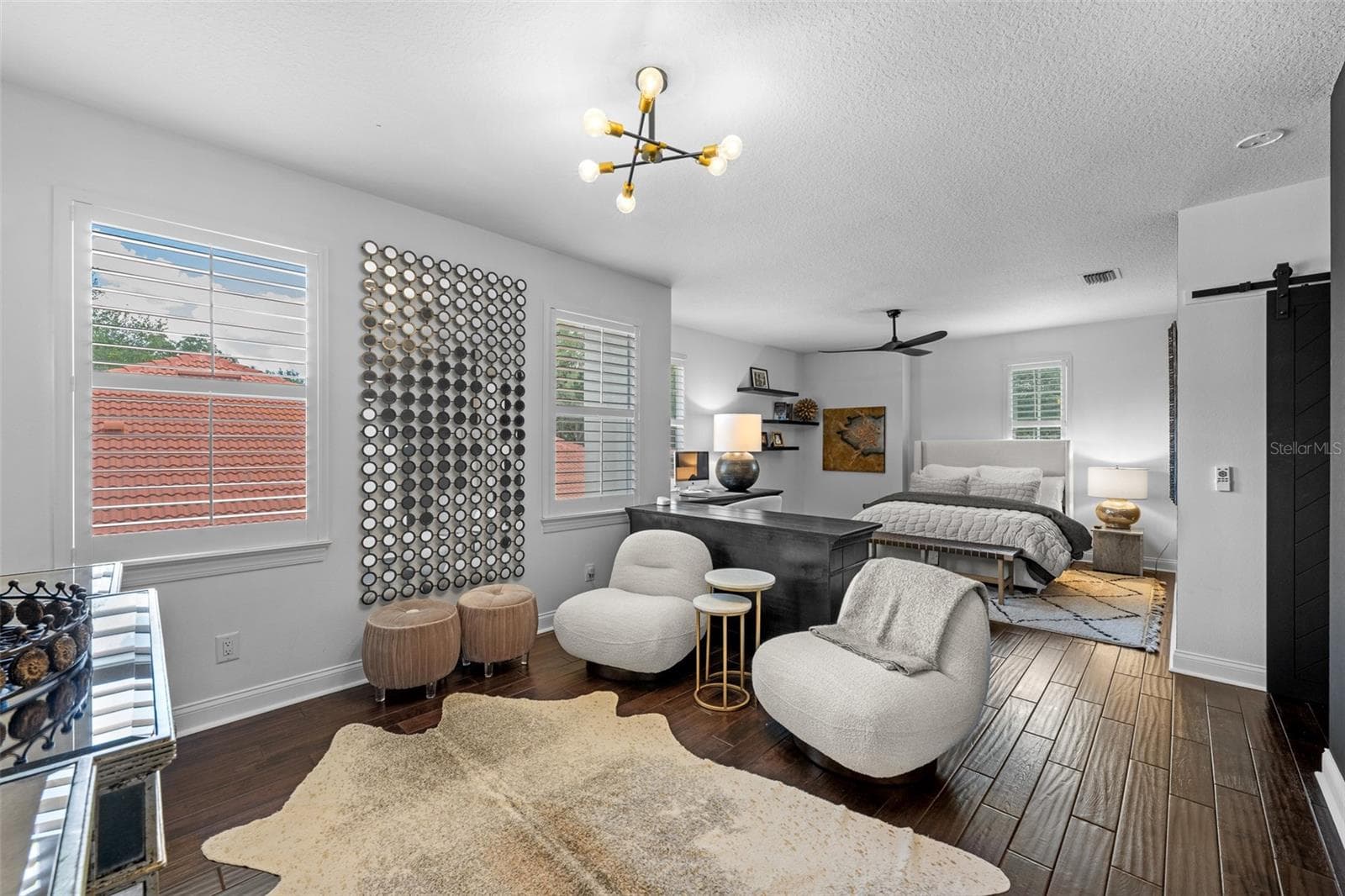 3rd Bedroom with sitting area — Bedroom with separate seating area, barn door, and modern light fixture. - 1921 FLORESTA VIEW DR, TAMPA