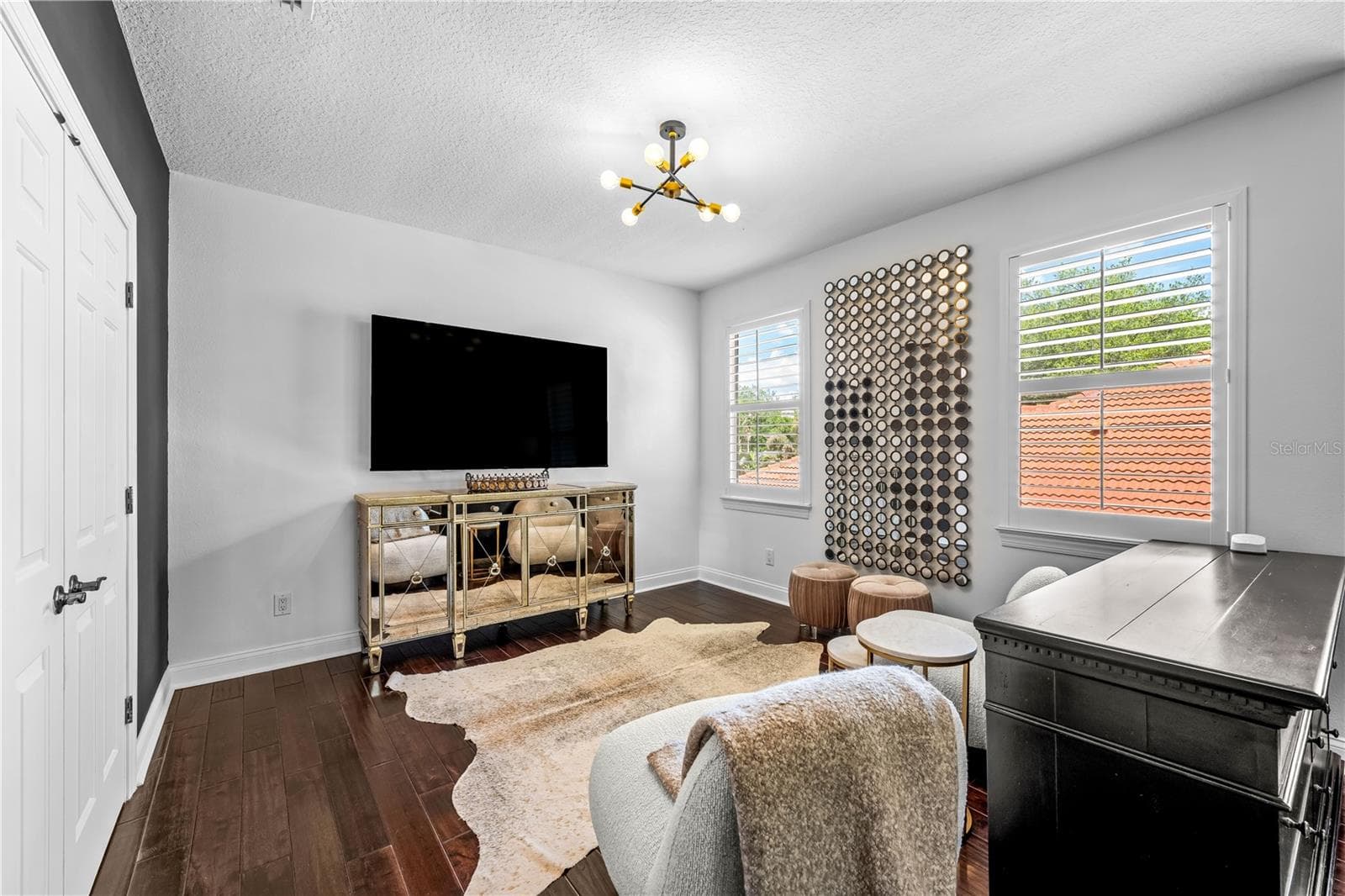 Sitting area with mounted TV and windows with plantation shutters. - 1921 FLORESTA VIEW DR, TAMPA