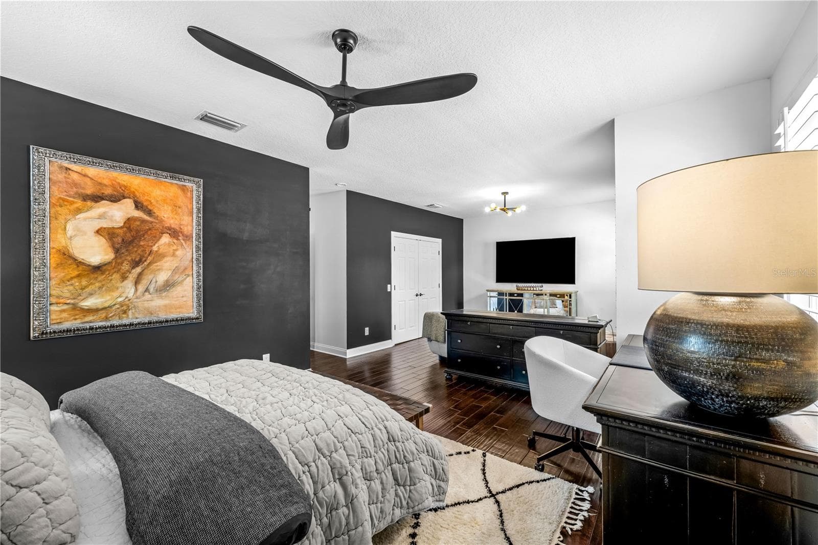3rd Bedroom - Dark accent wall, ceiling fan, and window with plantation shutters. - 1921 FLORESTA VIEW DR, TAMPA