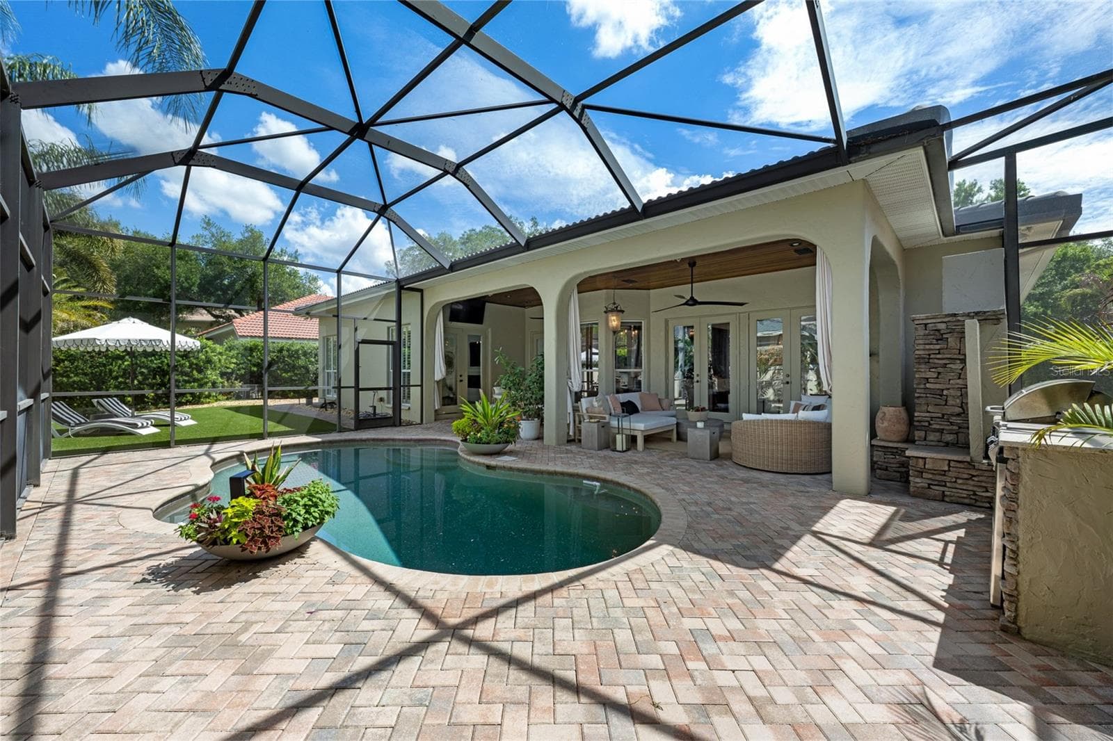 Screen-enclosed pool with brick paver deck and covered lanai. - 1921 FLORESTA VIEW DR, TAMPA