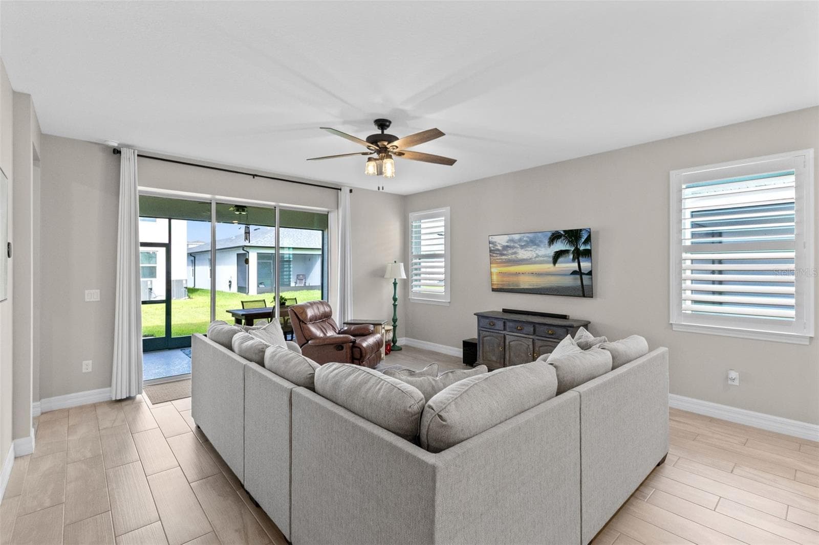 Family room features a triple sliding door and opens to the covered, screen enclosed back patio - 1274 SILO DR, ST CLOUD