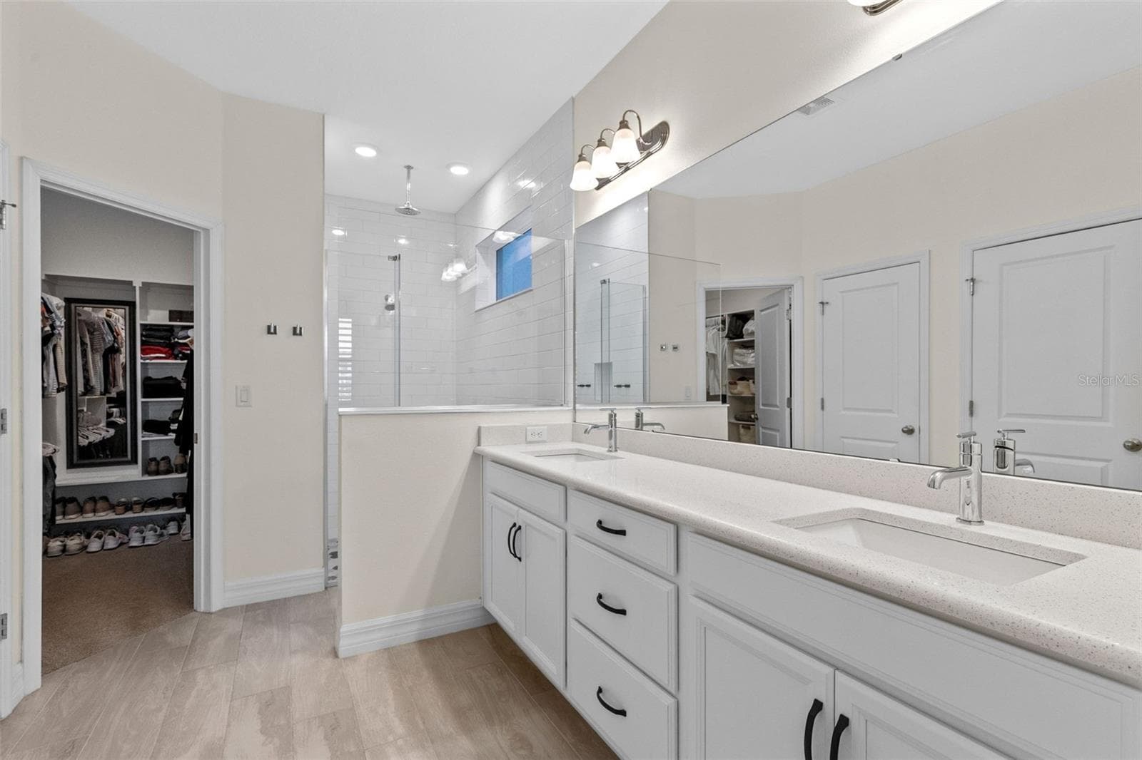 Primary bathroom features quartz countertops with double sinks, large walk in shower with seamless glass enclosure - 1274 SILO DR, ST CLOUD