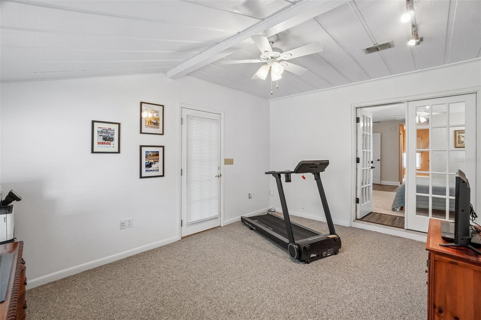 Bonus Room – Another view of the bonus room highlights its spacious layout, beamed ceiling detail, ceiling fan, additional storage, and direct connection to the primary bedroom. - 971 CORTLAND WAY, PALM HARBOR
