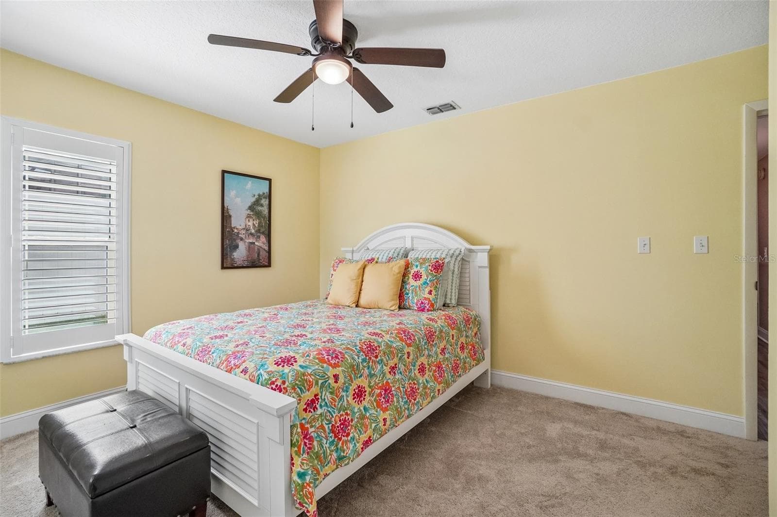 2nd Bedroom – This comfortable secondary bedroom offers soft carpeting, a ceiling fan, and a plantation-shuttered window that brings in natural light. - 971 CORTLAND WAY, PALM HARBOR