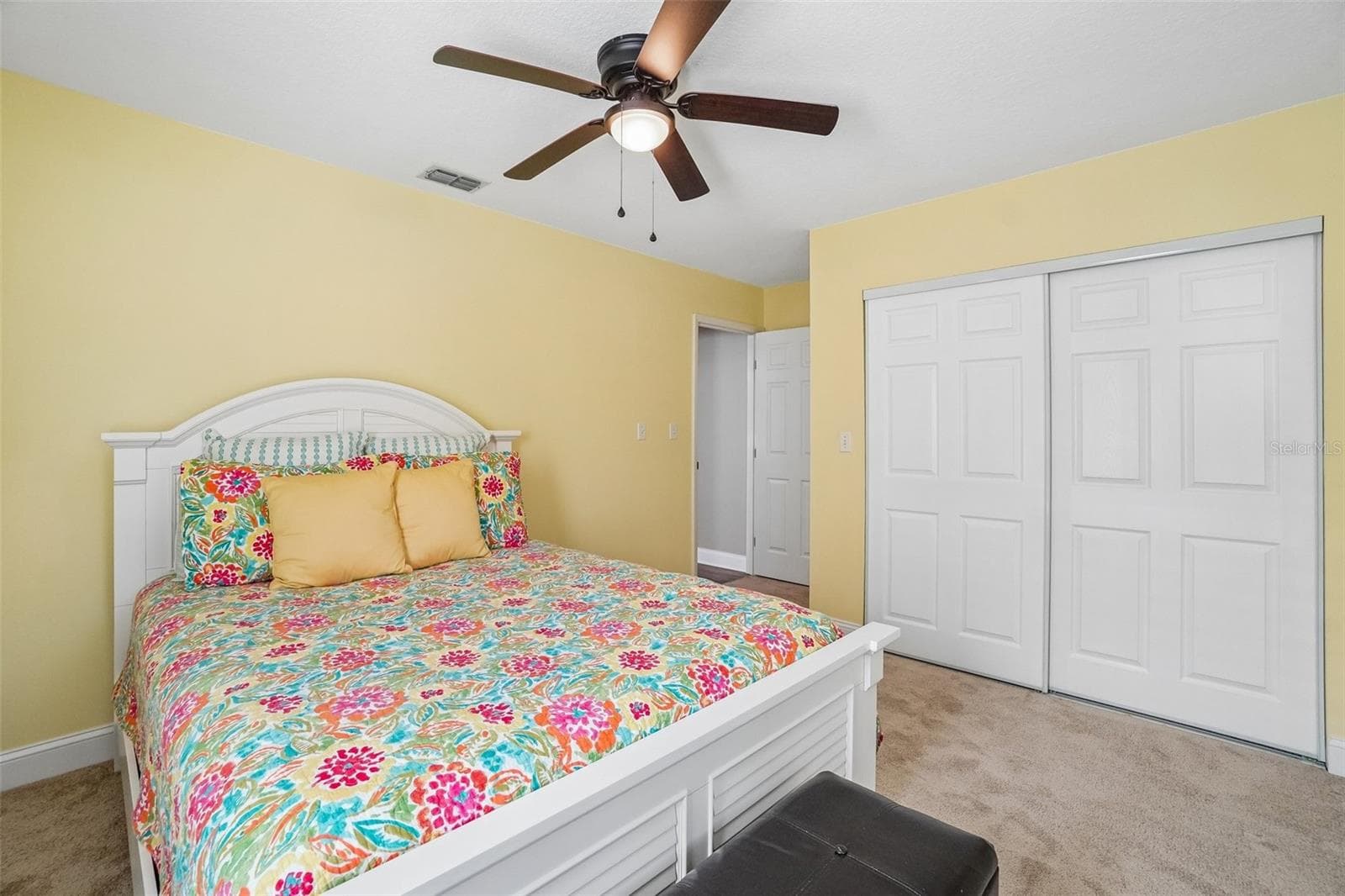 2nd Bedroom – Another view highlights the bedroom’s generous wall space, ceiling fan, carpeting, and wide sliding-door closet for convenient storage. - 971 CORTLAND WAY, PALM HARBOR