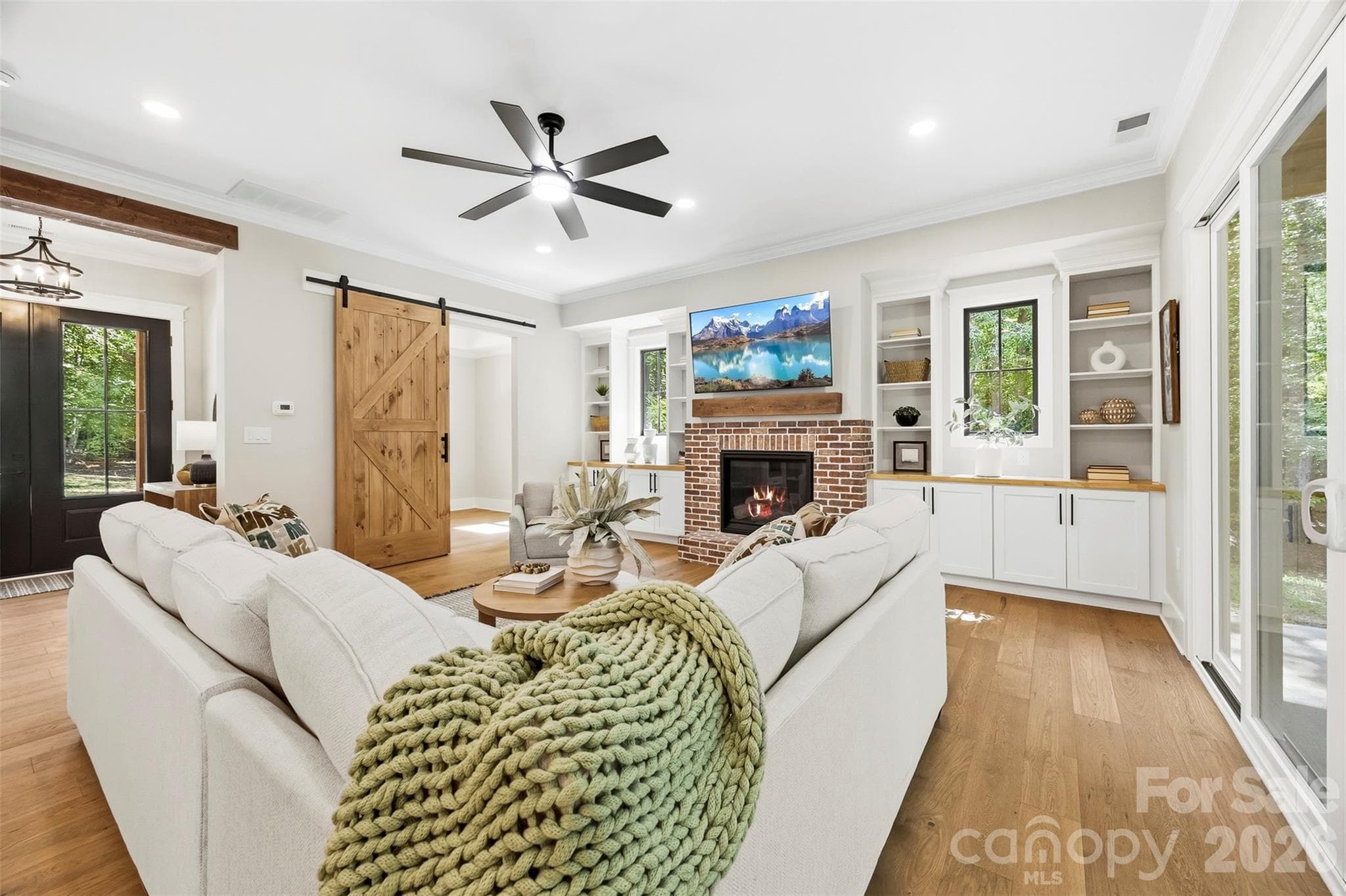 Living room with propane fireplace, built in cabinets and shelving, large sliding glass doors to back patio. - 3515 Capricorn Road, Lancaster