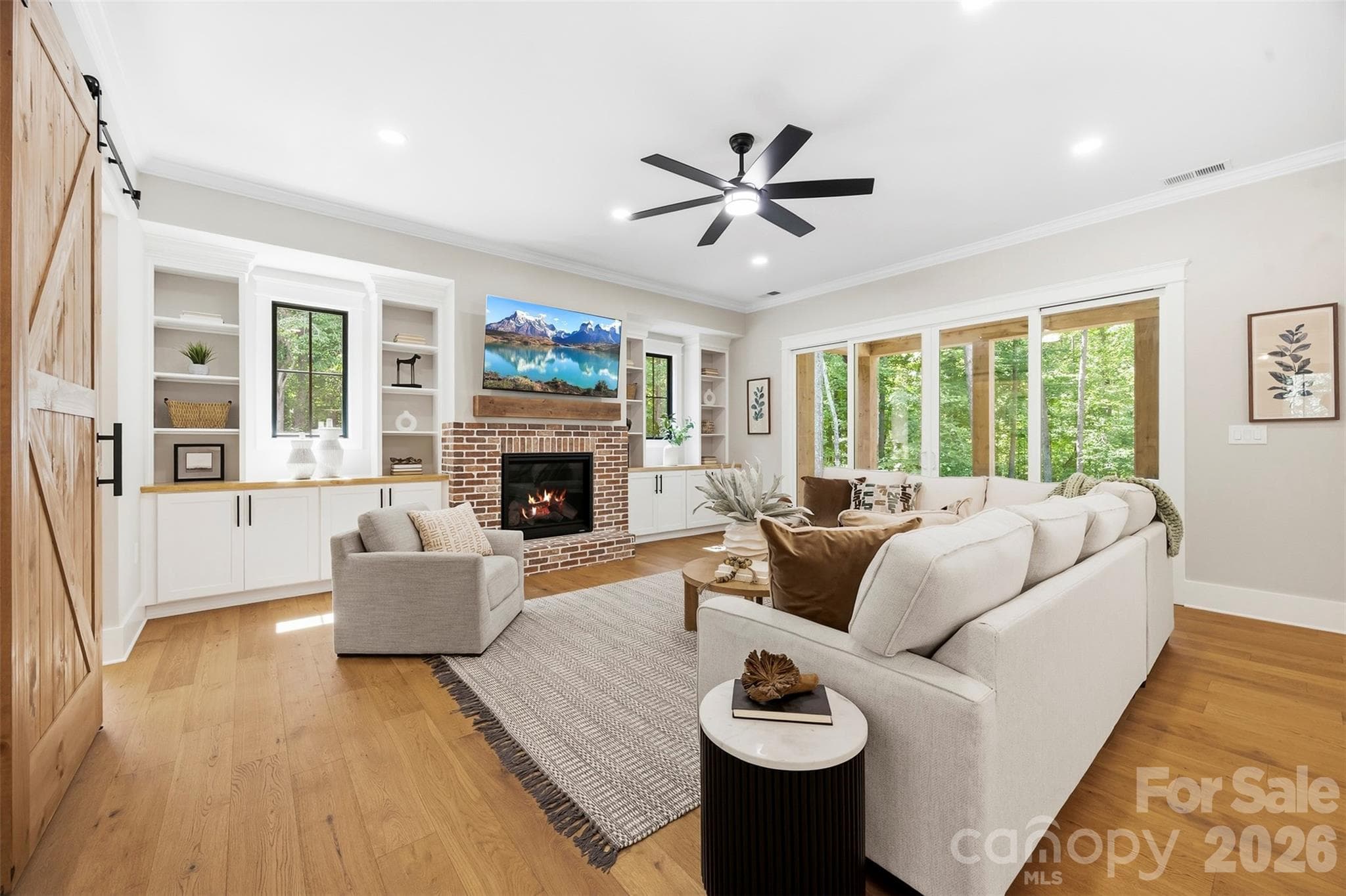 Living room with propane fireplace, built in cabinets and shelving, large sliding glass doors to back patio. - 3515 Capricorn Road, Lancaster