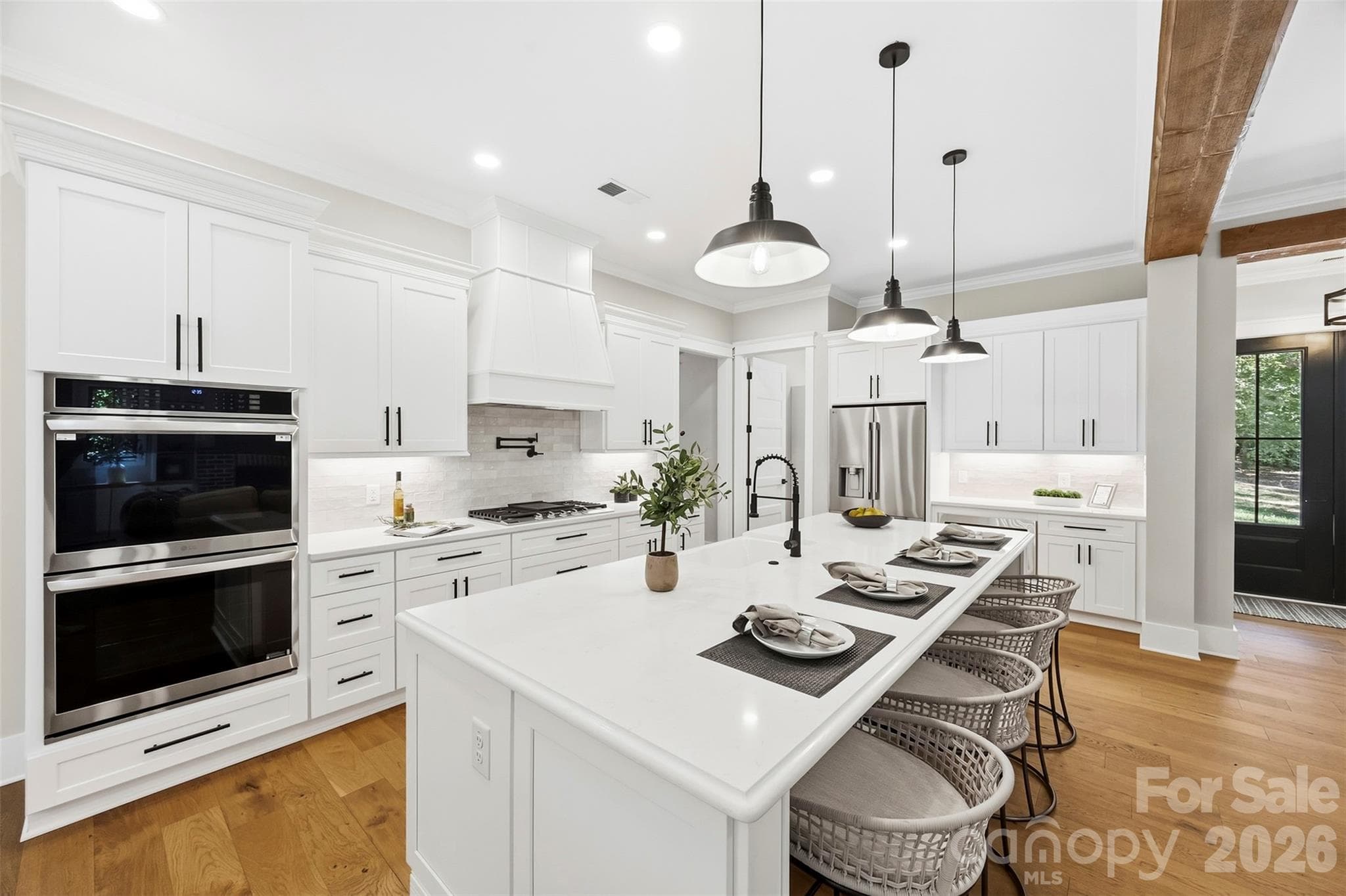 Kitchen with quartz counter tops, barstool seating for four, double oven, propane stove, built in microwave, pot filler, and walk in pantry with shelving. - 3515 Capricorn Road, Lancaster
