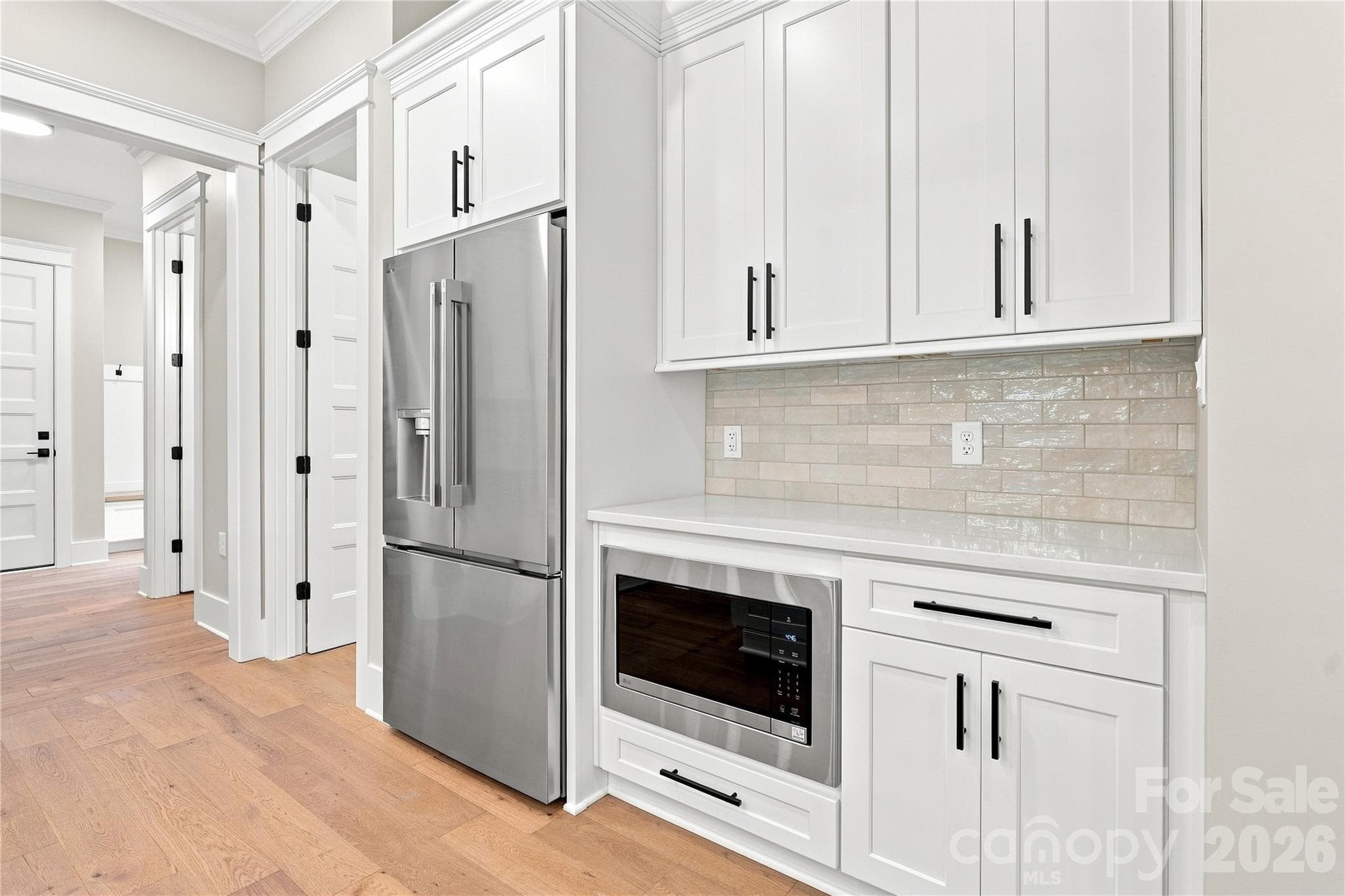 Kitchen with quartz counter tops, built in microwave, with hallway to powder room, mudroom, and garage. - 3515 Capricorn Road, Lancaster