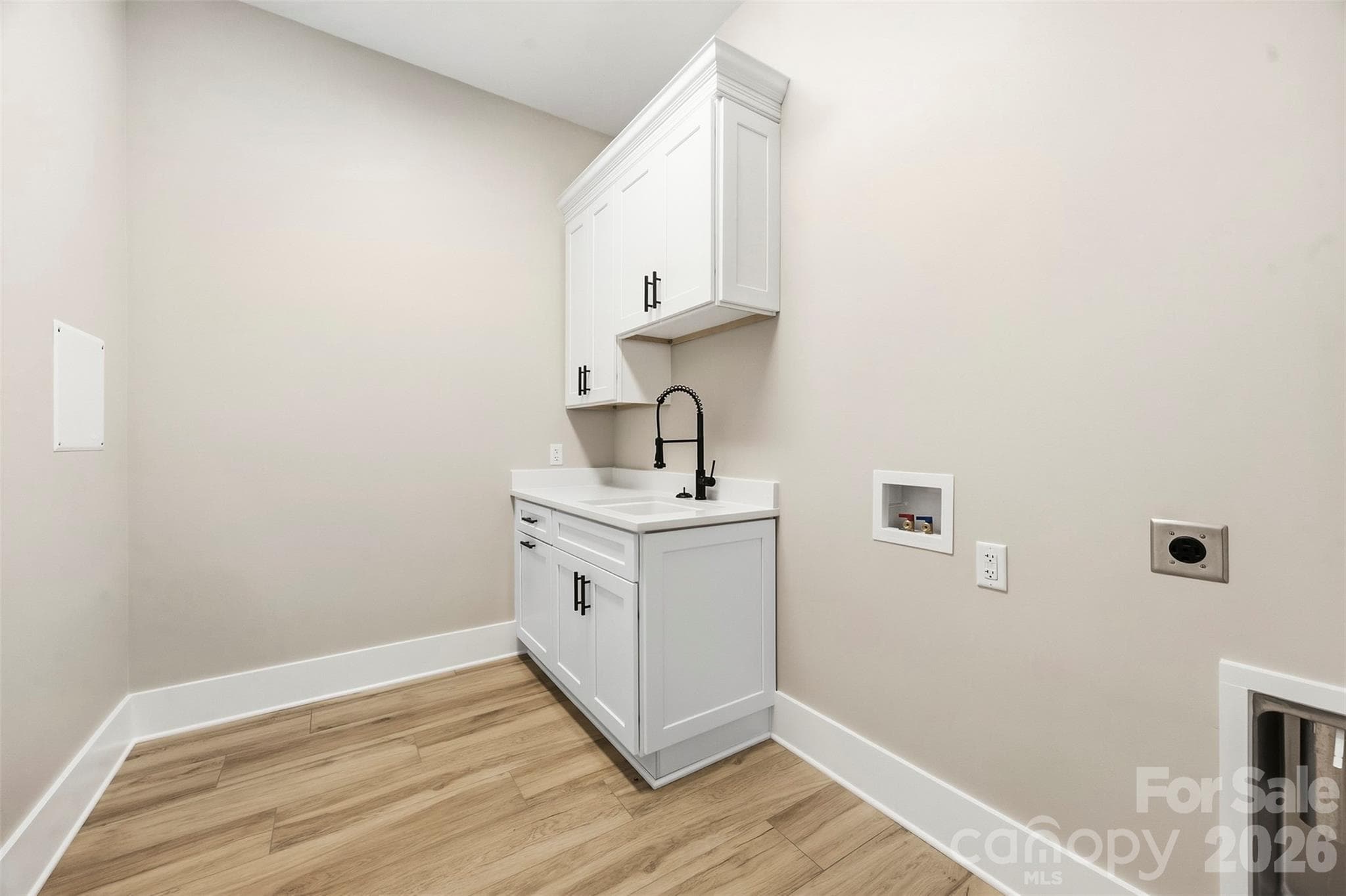 Laundry room with cabinets and sink. - 3515 Capricorn Road, Lancaster