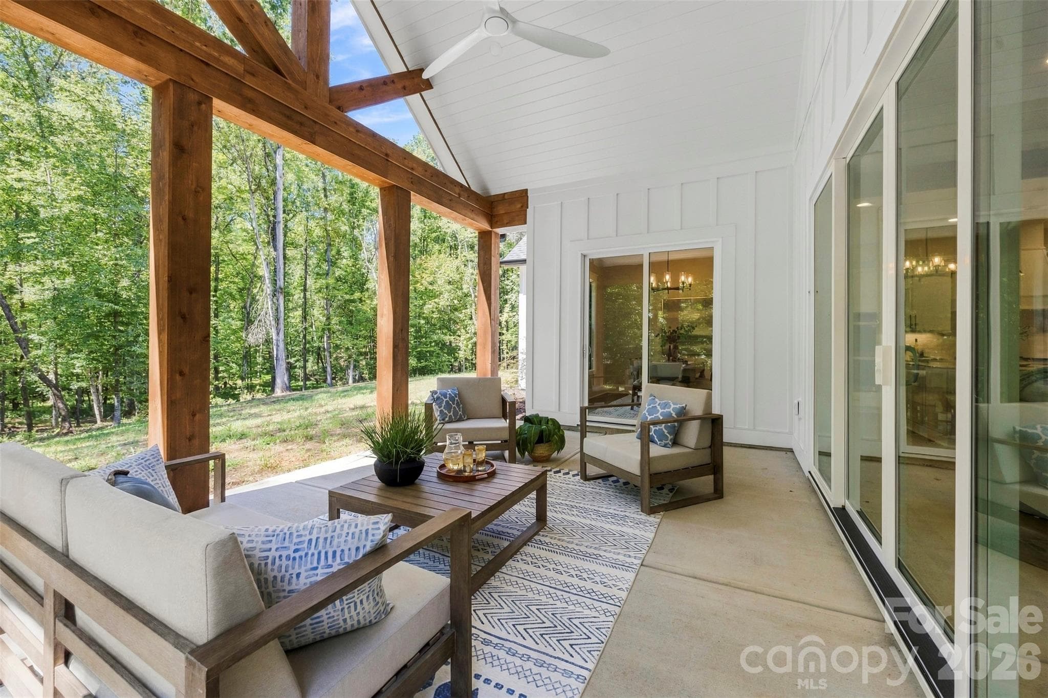 Back patio with sliding glass doors, large ceiling fan, and cedar beams. - 3515 Capricorn Road, Lancaster