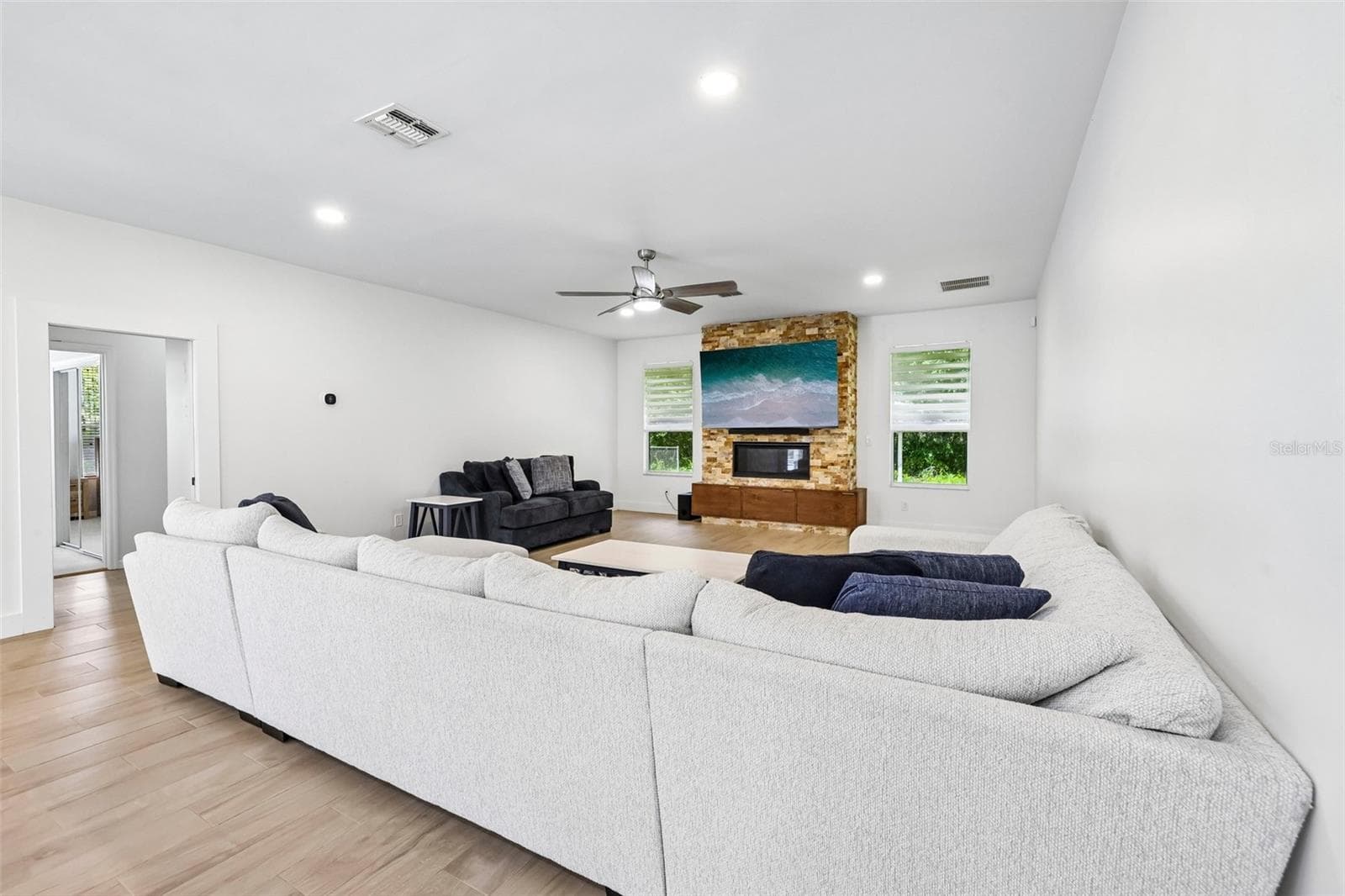 The spacious Living Room offers a beautiful LINEAR GAS FIREPLACE set into a STACKED STONE ACCENT WALL. - 19106 SHELDON ST, ORLANDO