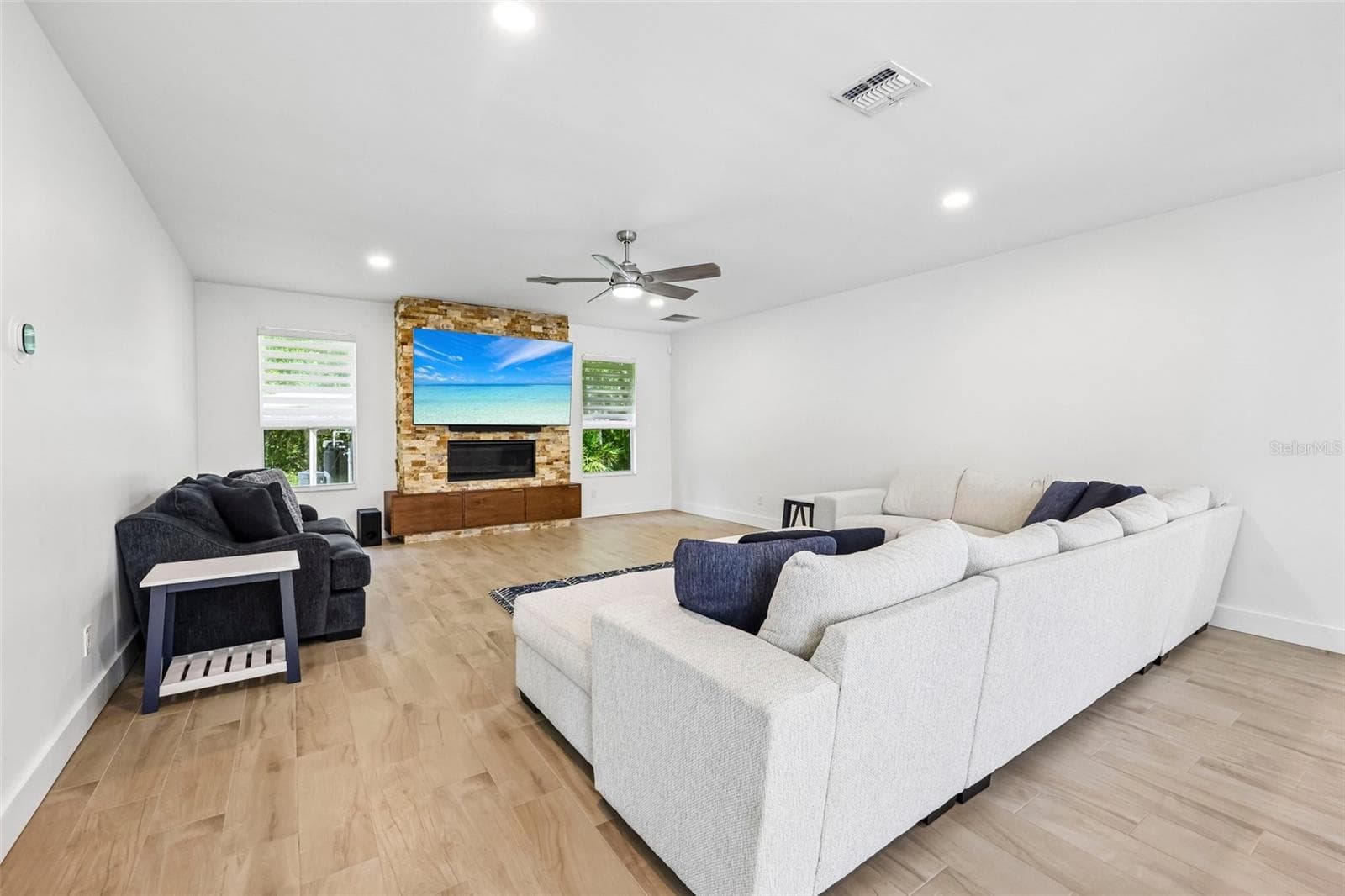 The spacious Living Room offers a beautiful LINEAR GAS FIREPLACE set into a STACKED STONE ACCENT WALL. - 19106 SHELDON ST, ORLANDO