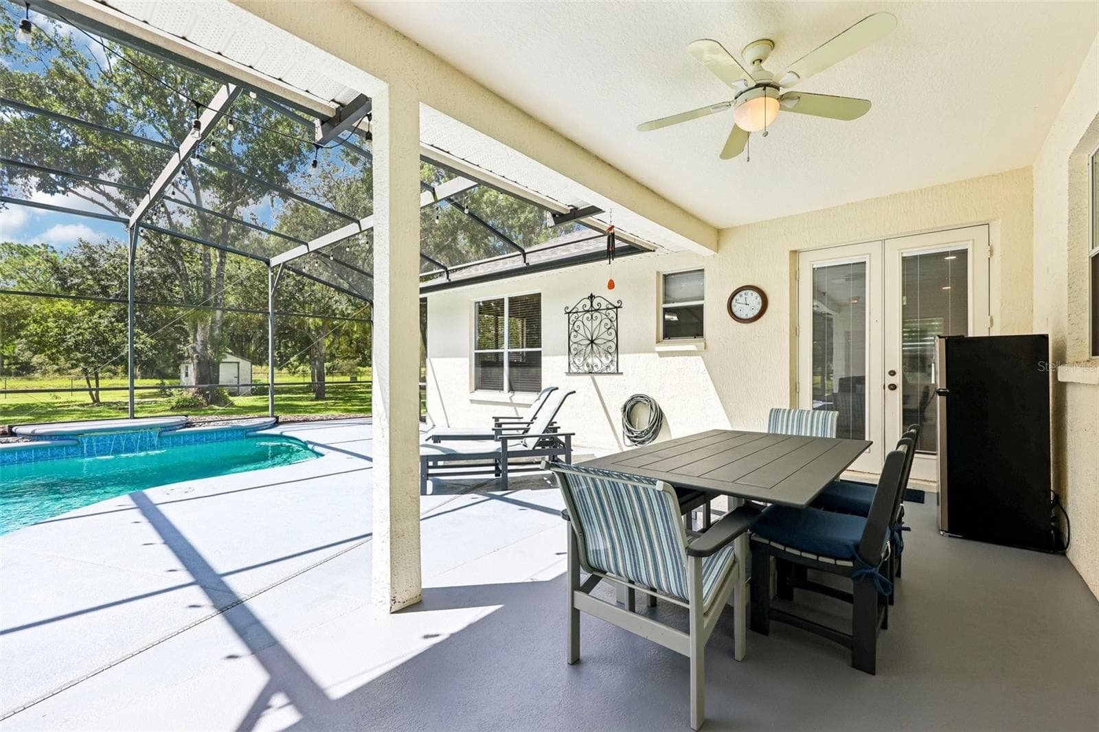 Step outside where the covered back patio and IN-GROUND POOL with WATERFALL FEATURE are enclosed within a screened lanai. - 19106 SHELDON ST, ORLANDO
