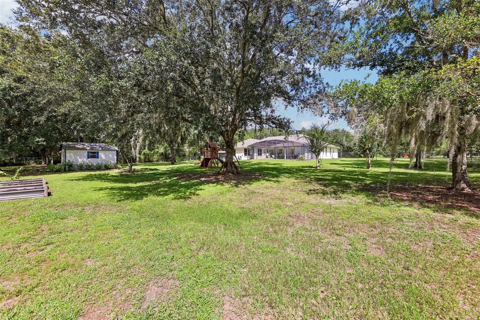 There's plenty of room to enjoy the acreage, with RAISED GARDEN BEDS, a SHED and a convenient STORAGE ROOM located on the back patio. - 19106 SHELDON ST, ORLANDO