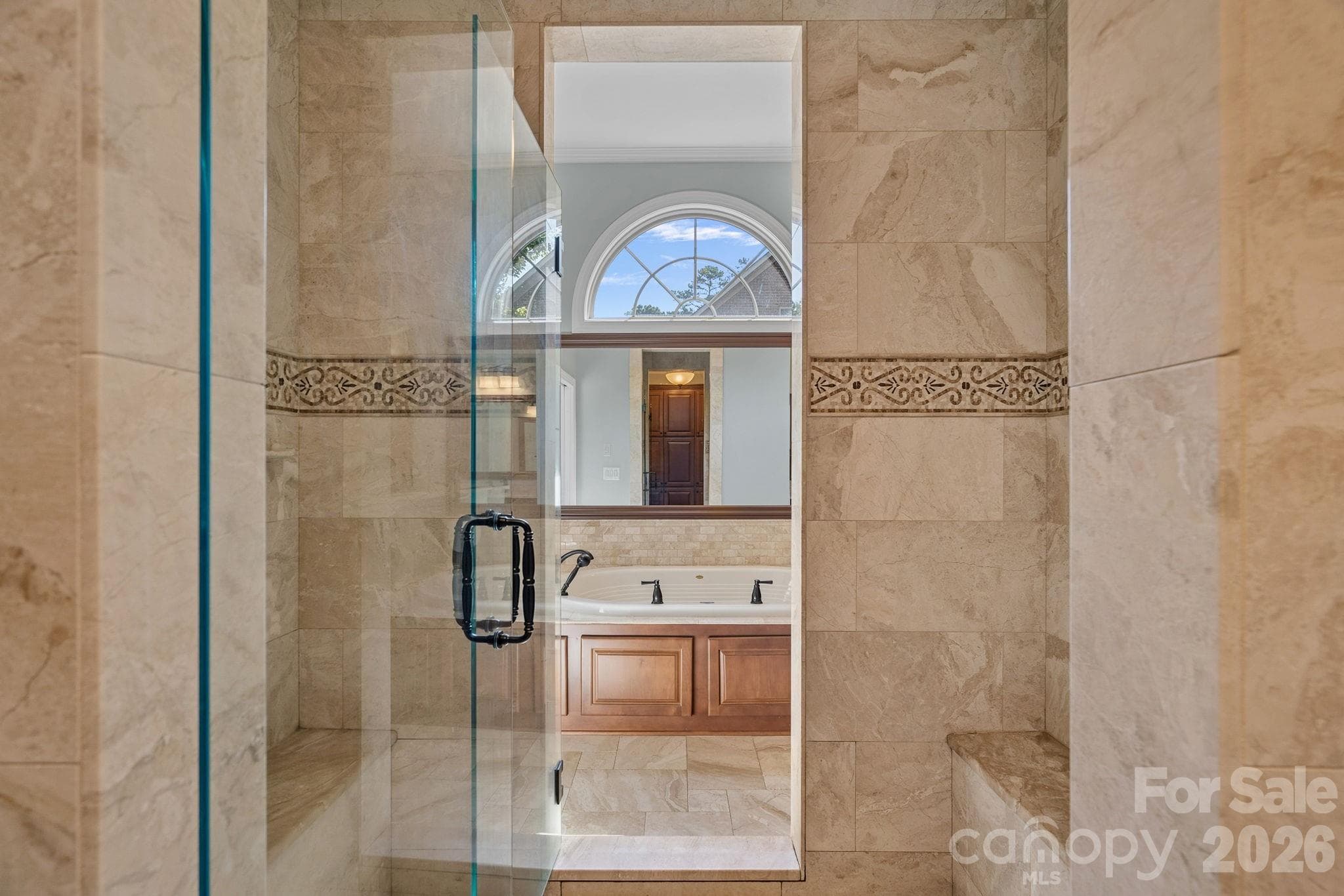 Large tiled shower connects two full primary bathrooms. - 1104 Longwood Court, Matthews