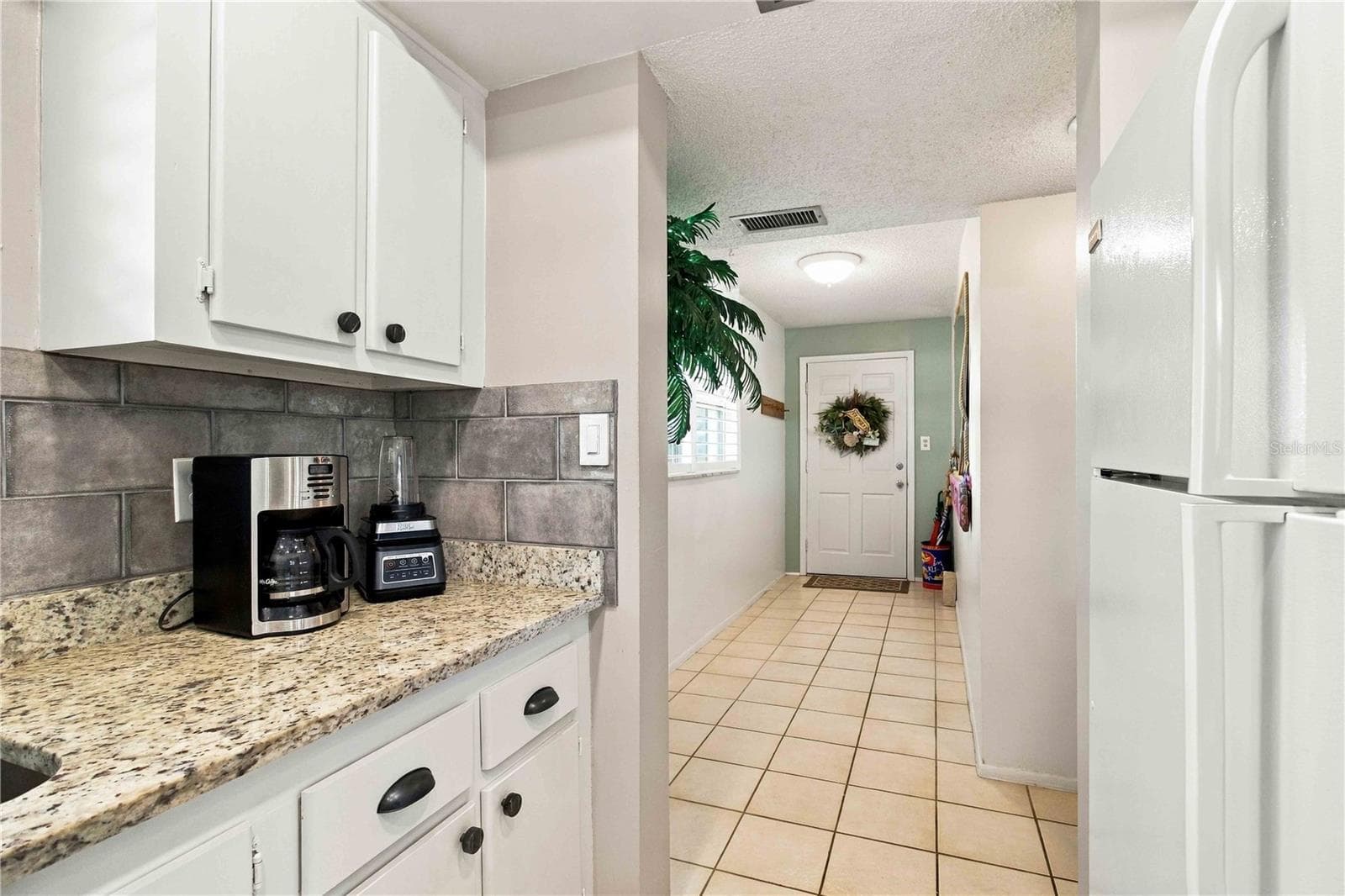 Kitchen featuring white appliances and granite counters - 304 47TH AVENUE DR W #313, BRADENTON