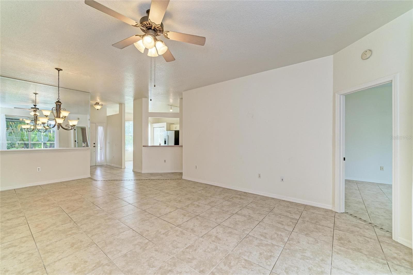 Living/dining area with kitchen passthrough. Primary bedroom to the right - 1101 CANE MILL LN, BRADENTON