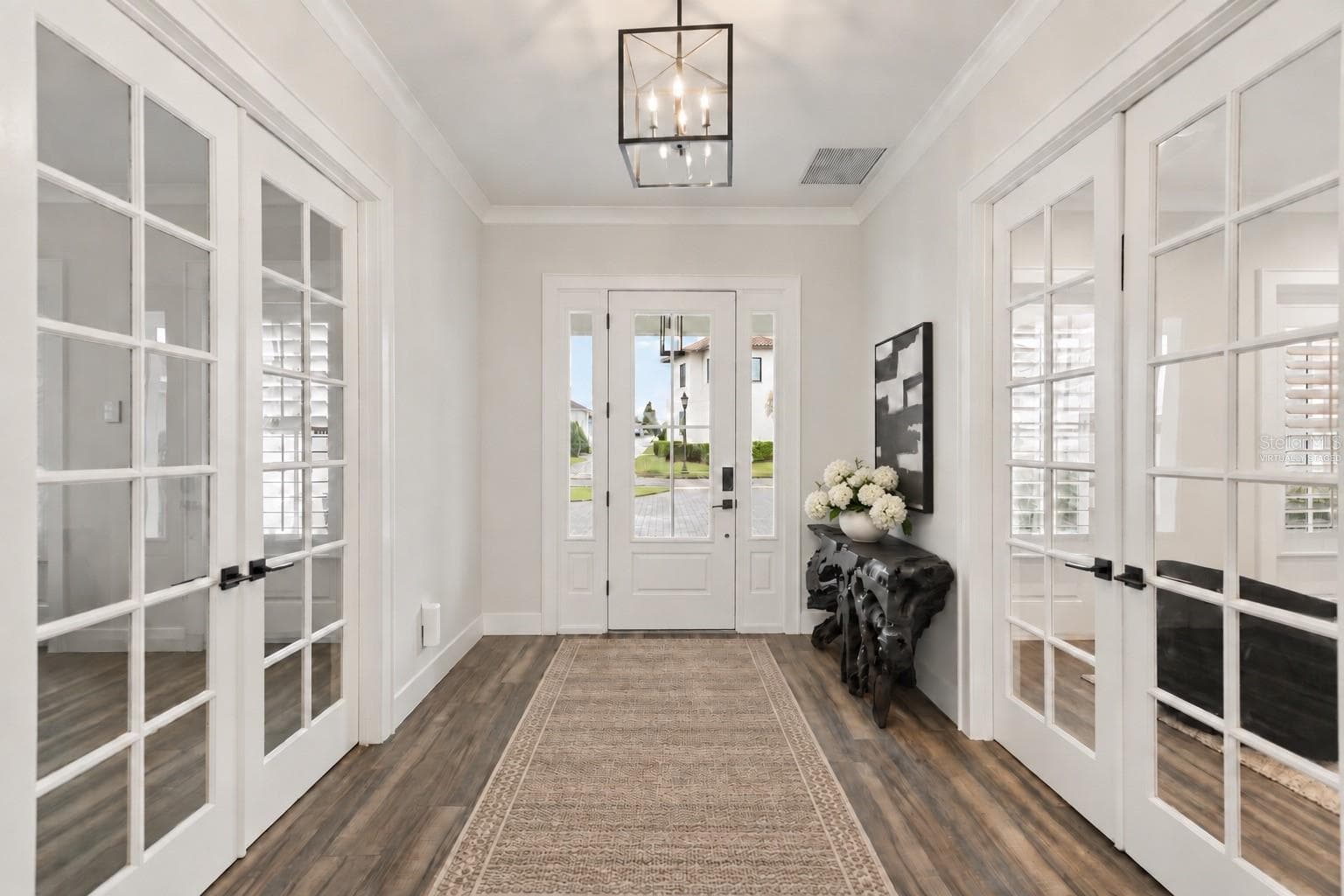 TWO PRIVATE ROOMS OFF THE FOYER Looking toward the front entry, the foyer is framed by double French doors leading to a dedicated executive office on one side and a flexible en suite guest or au pair room on the other - 907 CELADON ST, WINTER GARDEN