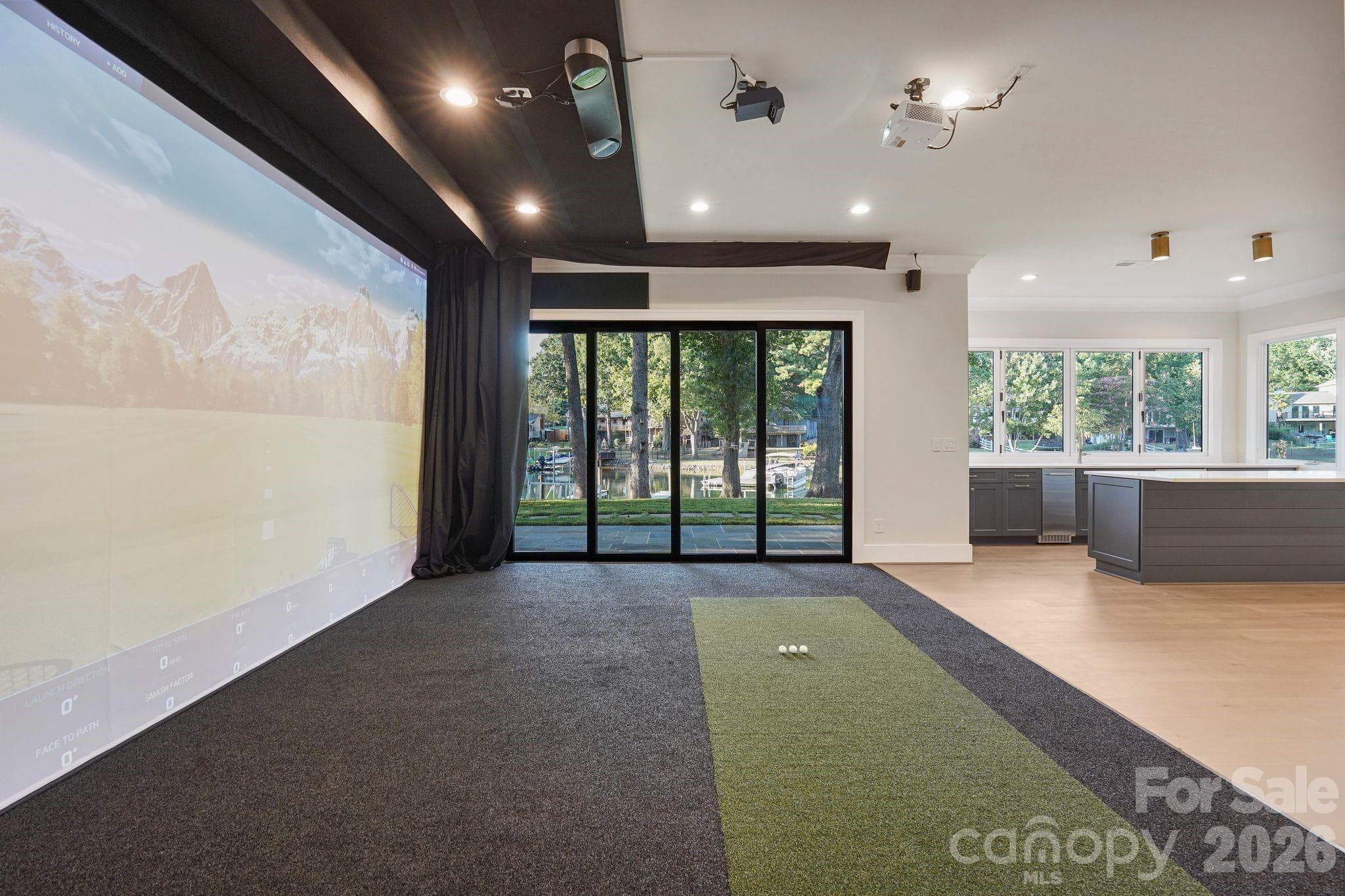 State-of-the-art golf simulator featuring multi-sport capabilities and a 4K projection system, seamlessly transforming into a private home theater for the ultimate entertainment experience. - 21216 Rio Oro Drive, Cornelius