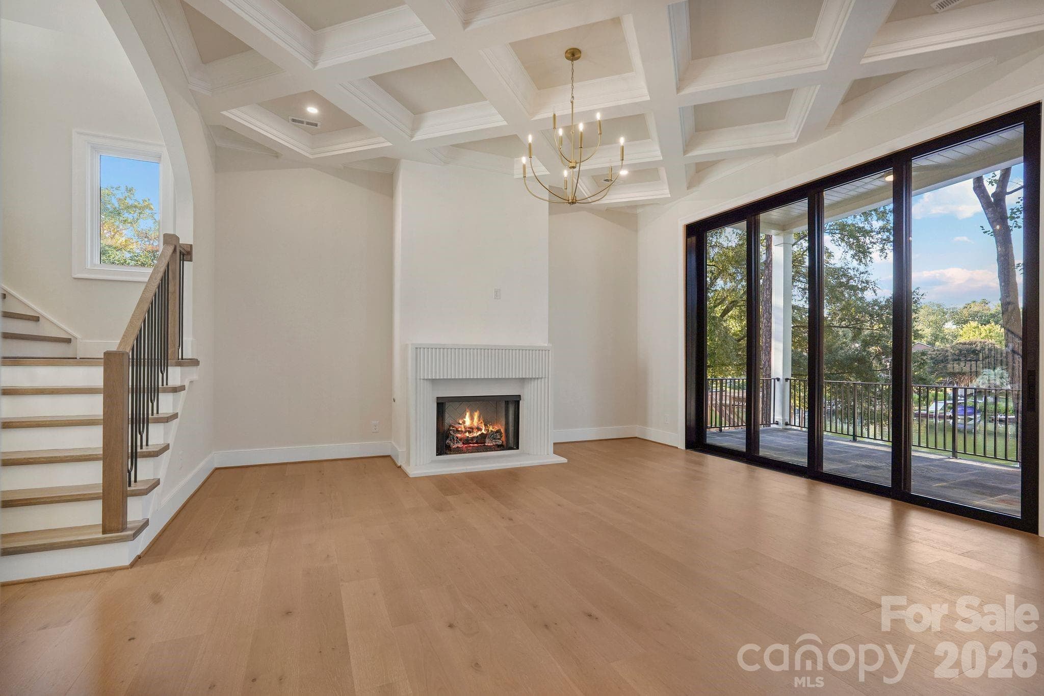 Custom limestone fireplace surround paired with a Venetian plaster feature wall, creating a sophisticated focal point in the family room. - 21216 Rio Oro Drive, Cornelius