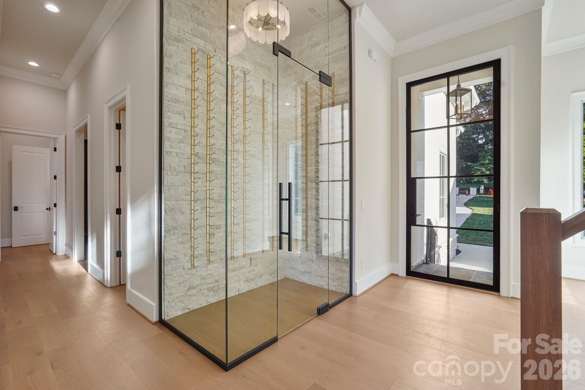 Elegant foyer featuring 7" white oak flooring and a thoughtfully concealed powder room, providing added privacy while maintaining a clean, sophisticated entry. - 21216 Rio Oro Drive, Cornelius