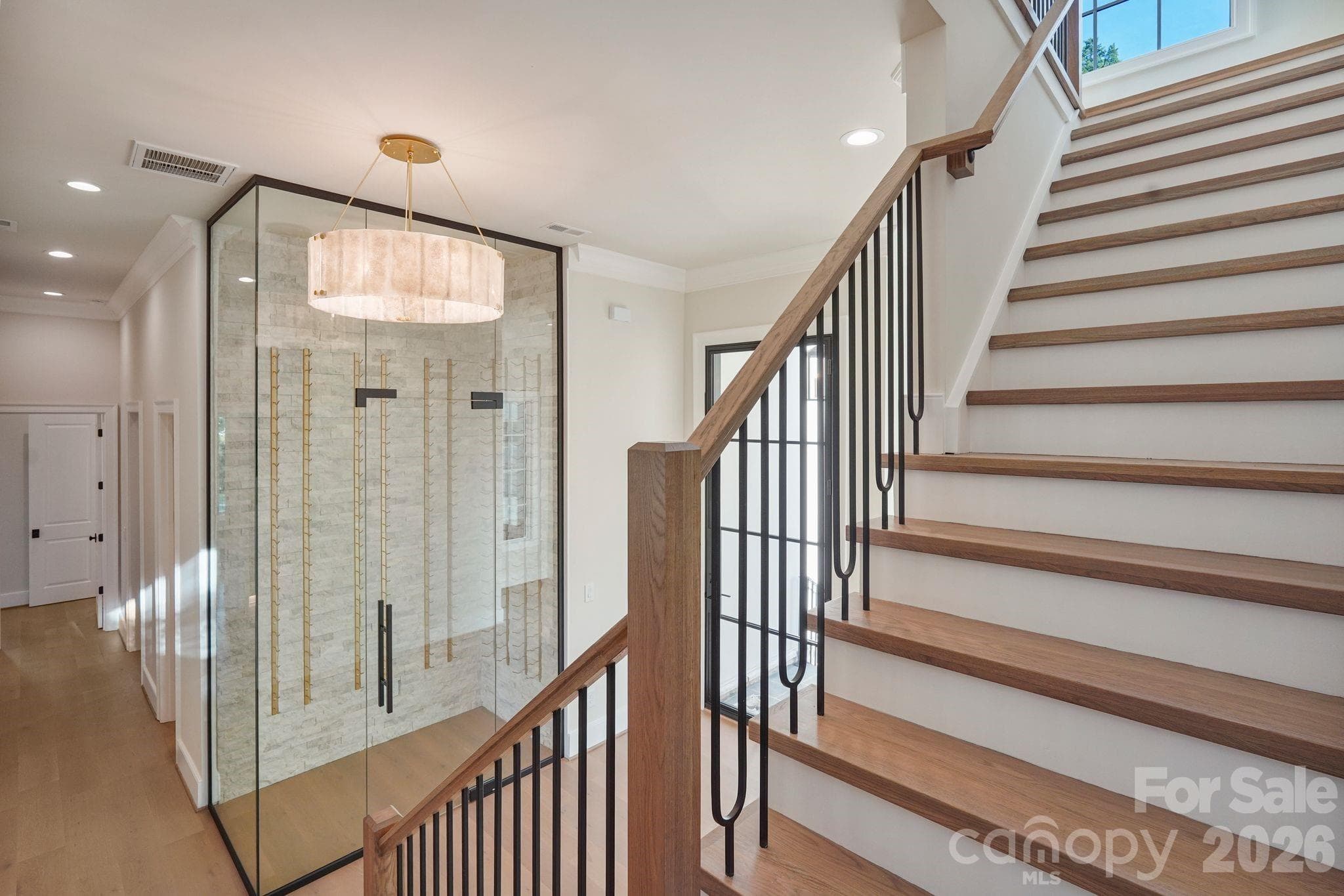 Dramatic 12' glass-enclosed wine room featuring a custom glass door with hydraulic operation for added safety and security. - 21216 Rio Oro Drive, Cornelius