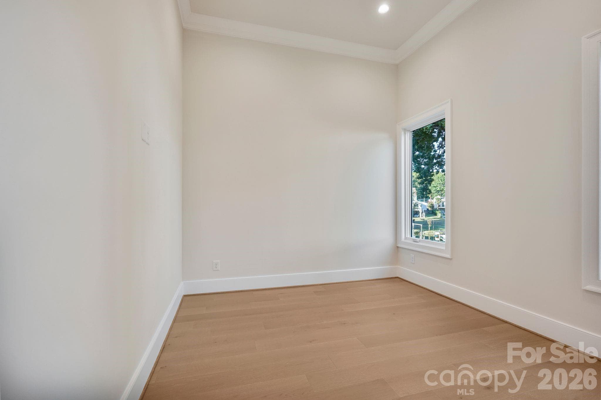 Private main-level retreat featuring soaring 12' ceilings and beautiful lake views, offering a quiet escape from the home’s main living spaces. - 21216 Rio Oro Drive, Cornelius