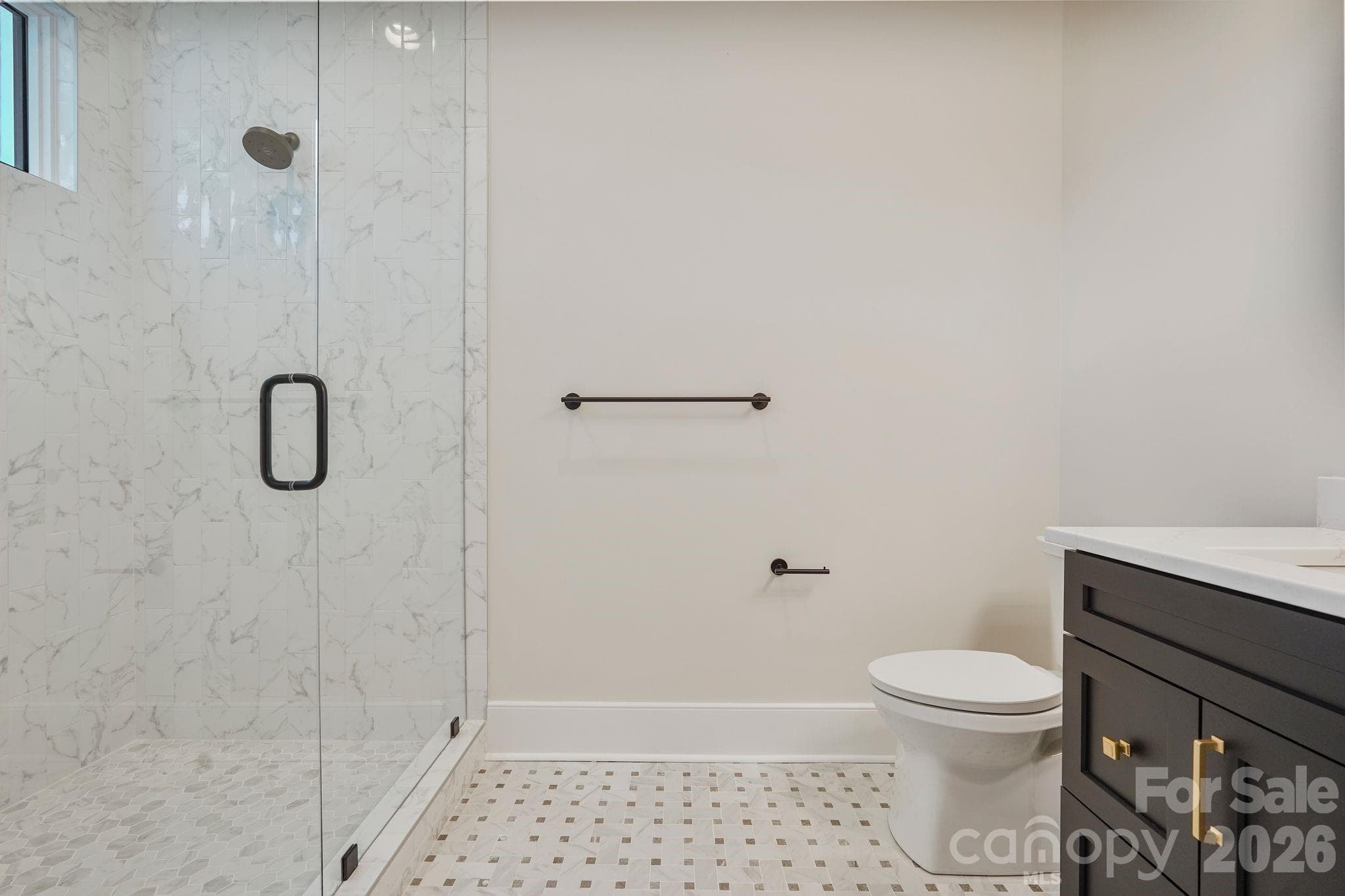 Main level guest ensuite with shower thoughtfully framed to a 10' ceiling height to help retain warmth and steam, with a transom window bringing in natural light while maintaining privacy. - 21216 Rio Oro Drive, Cornelius
