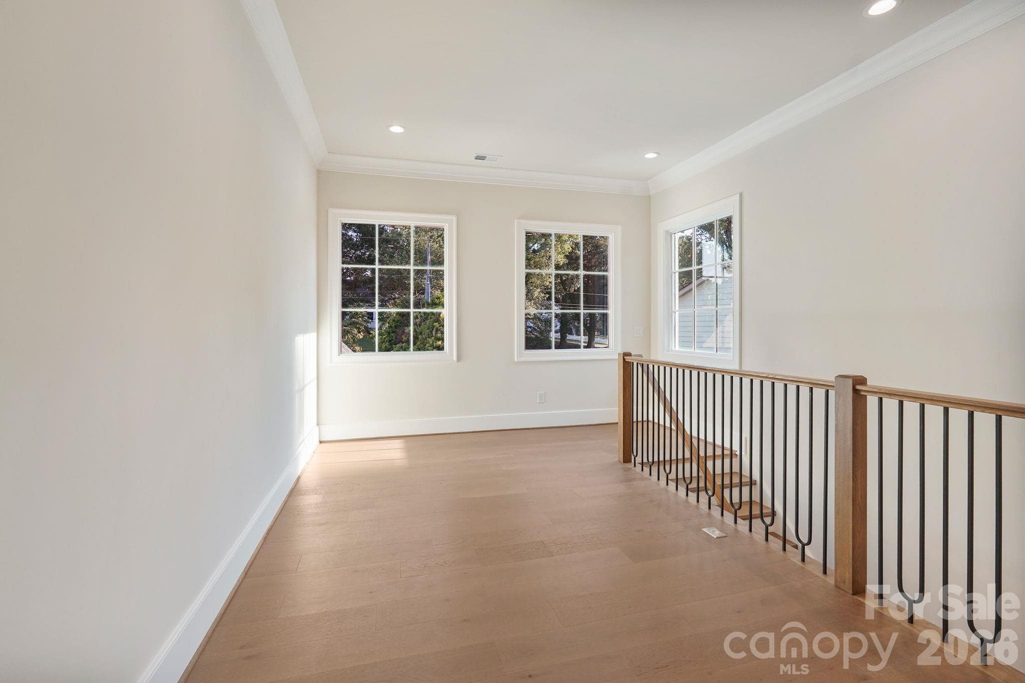 Upstairs gallery filled with natural light from expansive windows, creating an open, airy transition while capturing beautiful main-channel water views. - 21216 Rio Oro Drive, Cornelius