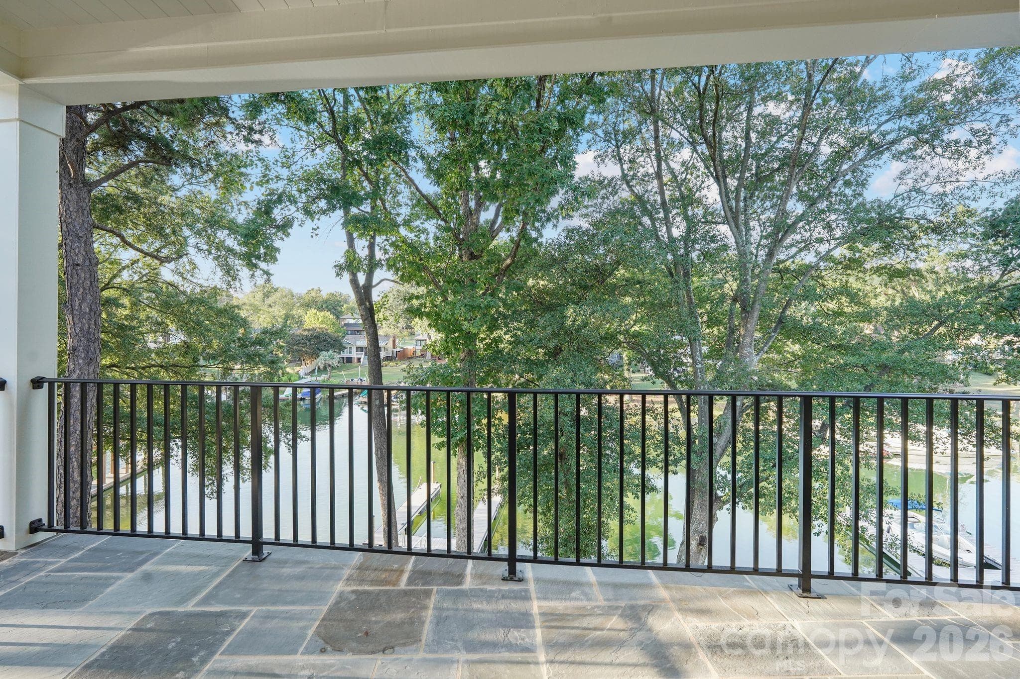 Private primary suite balcony creates an intimate outdoor retreat with beautiful water views and a peaceful setting to enjoy the lake. - 21216 Rio Oro Drive, Cornelius