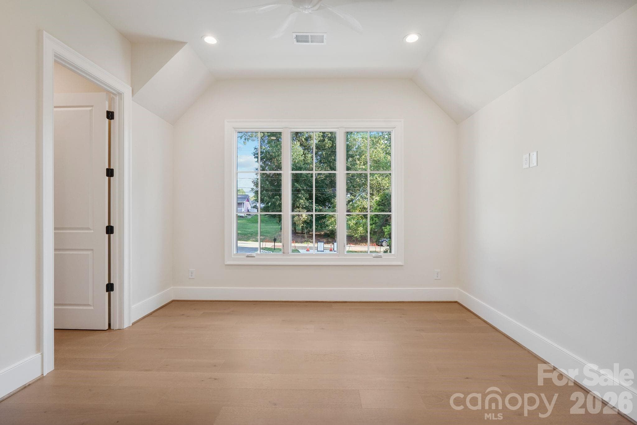 Bedroom 4 features large windows for abundant natural light, a spacious walk-in closet, and convenient access to additional attic storage. - 21216 Rio Oro Drive, Cornelius