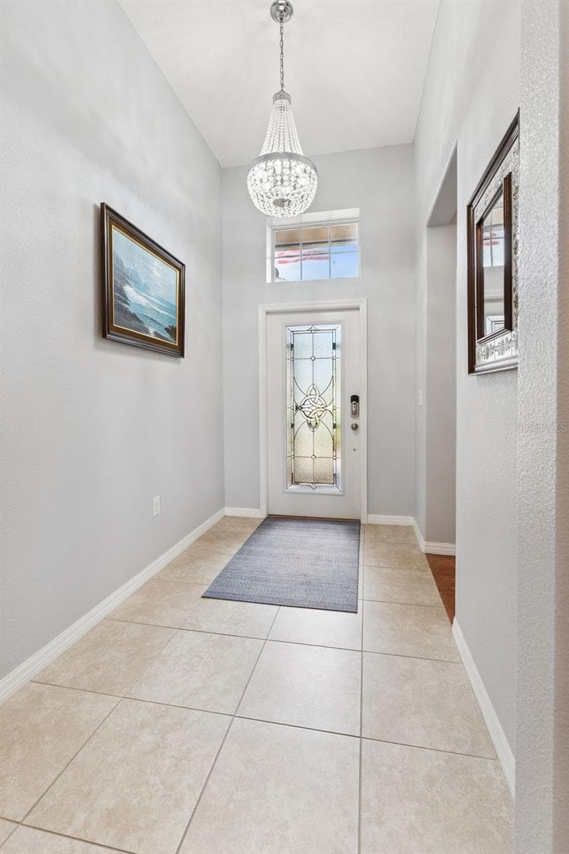 Custom Leaded Glass Front Door, Transom Window and Chandelier enhance the foyer - 3541 RALEIGH DR, WINTER HAVEN
