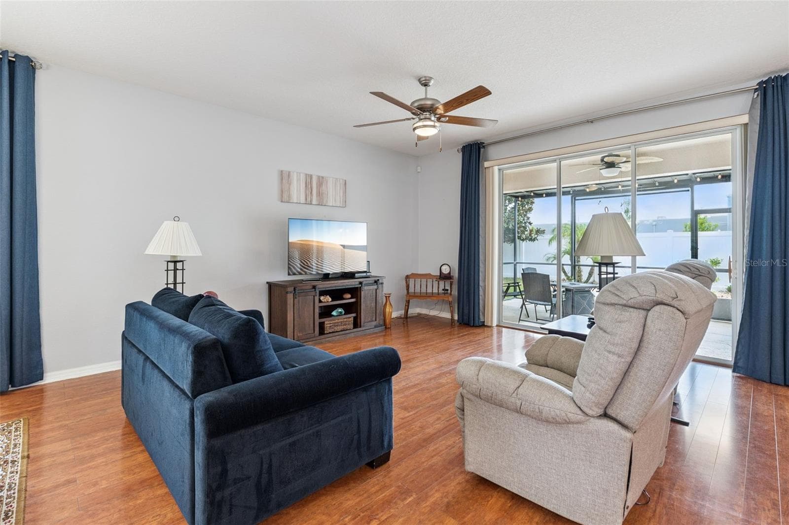 The spacious Living Room is enhanced with triple glass sliding doors that open to the extended lanai, seamlessly blending indoor and outdoor living. - 3541 RALEIGH DR, WINTER HAVEN