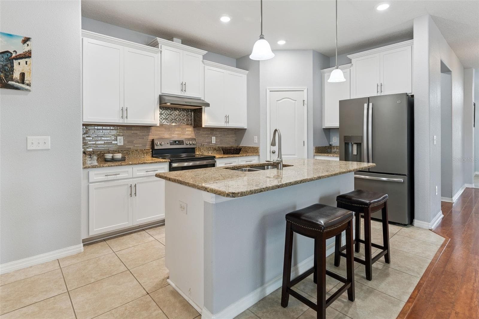 The well-equipped kitchen is a chef’s delight, with fingerprint-resistant stainless-steel appliance package, recessed lighting, and 42-inch white upper cabinetry enhanced with crown molding, soft-close hinges, and brush nickel hardware. A generous walk-in pantry provides additional storage, while the pull-out cabinet organizers keep everyday items conveniently within reach. - 3541 RALEIGH DR, WINTER HAVEN