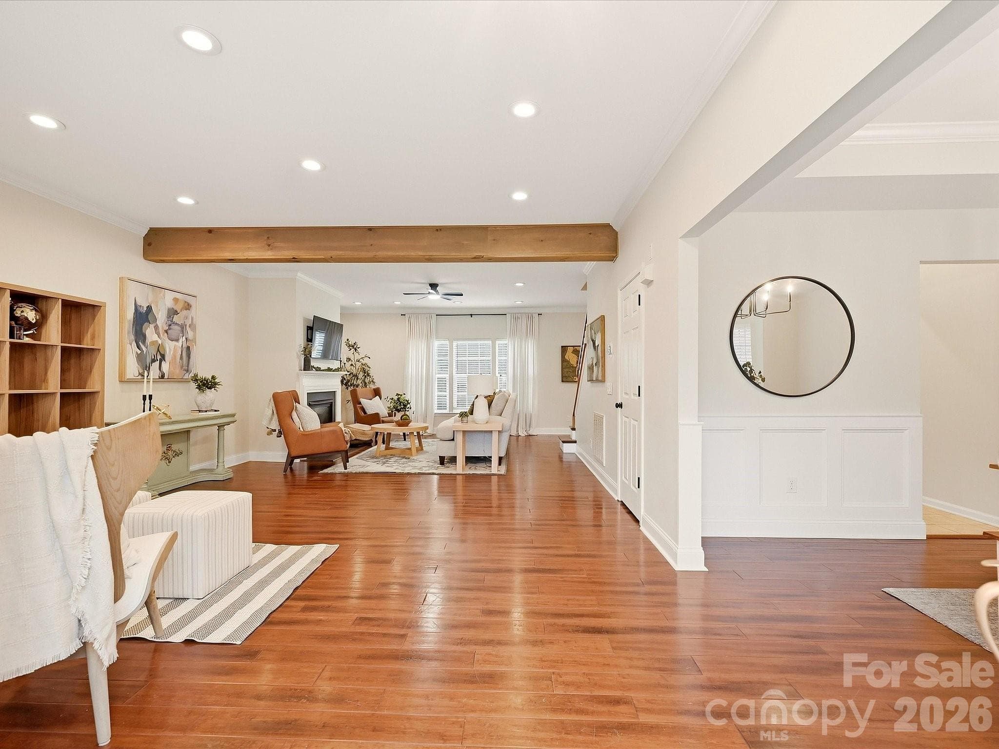 A welcoming entrance opens into expansive living spaces with rich wood floors, warm exposed beams, and an airy flow throughout the home. - 16006 Lavenham Road, Huntersville