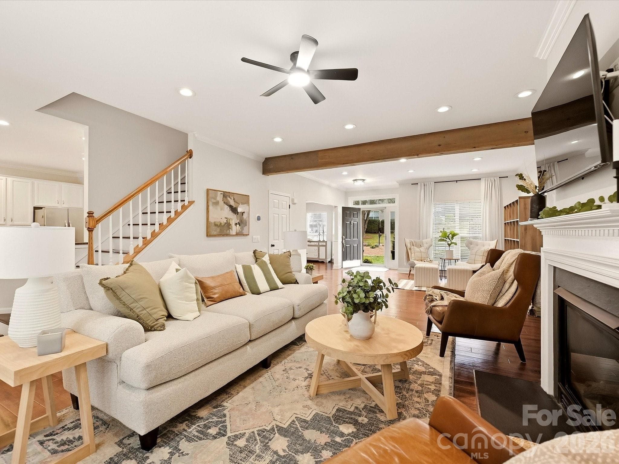 The inviting Great Room features a cozy fireplace, rich wood floors, abundant natural light, and plenty of space for comfortable everyday living. - 16006 Lavenham Road, Huntersville
