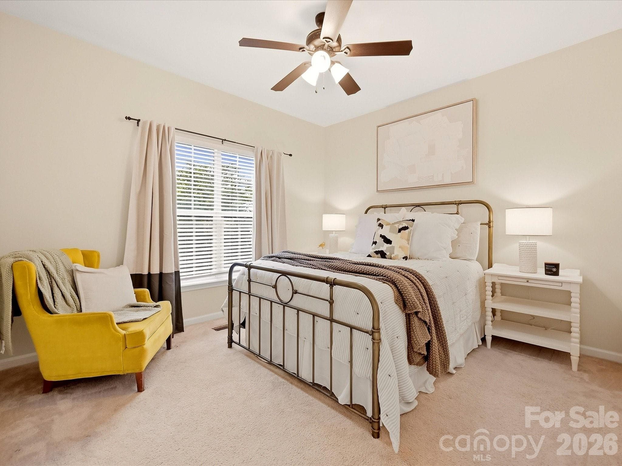 Guest suite on main level offers a comfortable retreat with soft neutral finishes, natural light, generous space, and a ceiling fan for added comfort. - 16006 Lavenham Road, Huntersville