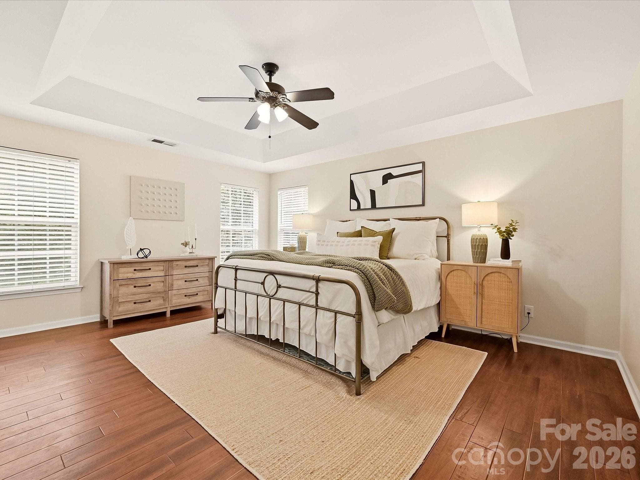 The spacious primary suite features wood floors, a tray ceiling, abundant natural light, and a generous walk-in closet for added comfort and convenience. - 16006 Lavenham Road, Huntersville