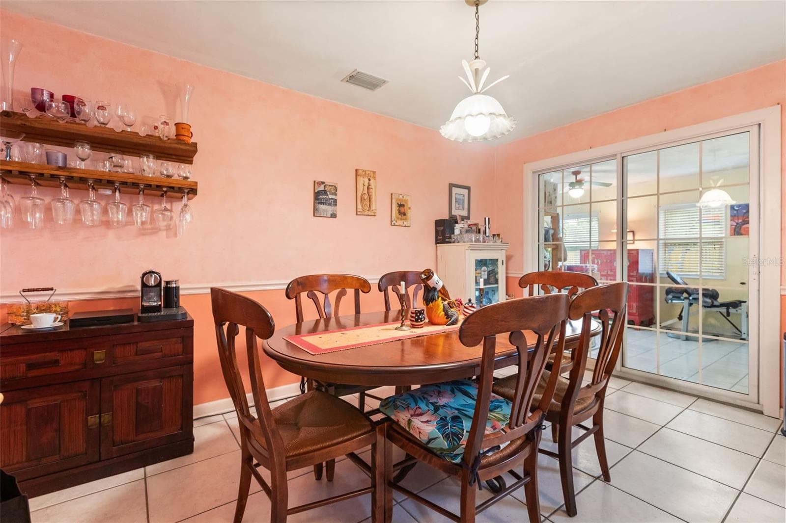 Dining room with one of the air conditioned bonus rooms through sliding glass doors. - 4511 LONGWORTH DR, ORLANDO