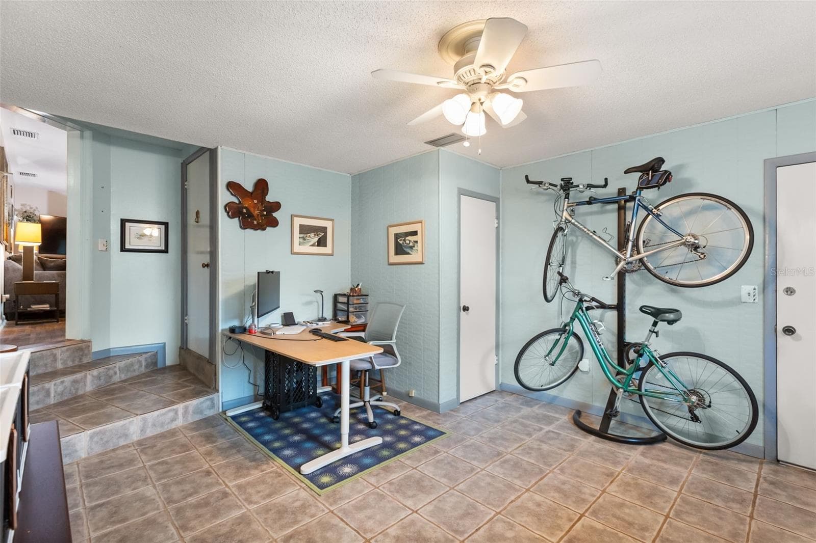 One of the downstairs bonus rooms has a storage closet (by bicycles). The door to the left leads upstairs. The door to the right leads to the garage. Living room is seen in the far left. - 4511 LONGWORTH DR, ORLANDO