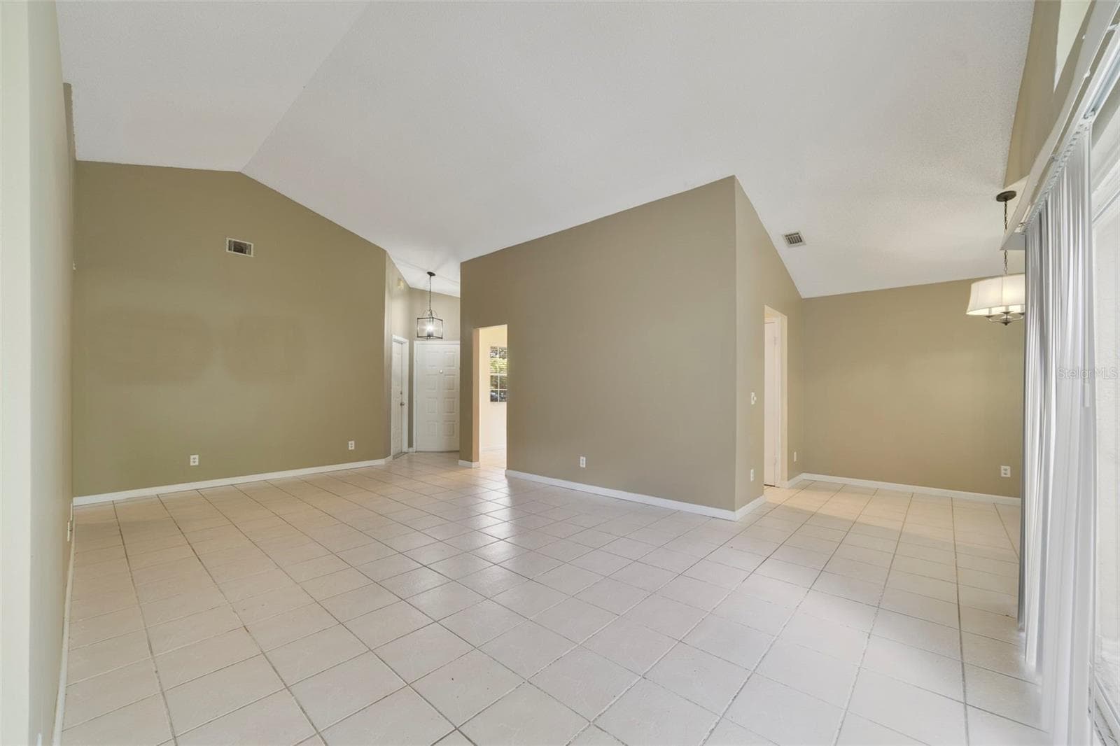 The spacious Living Room immediately catches your eye with its VAULTED CEILING, a unique decorative ledge and an ARCHED WINDOW positioned above the sliding glass doors that open to the back patio and SPACIOUS YARD, creating an easy connection between the indoor and outdoor spaces. - 713 MEADOWSIDE CT, ORLANDO