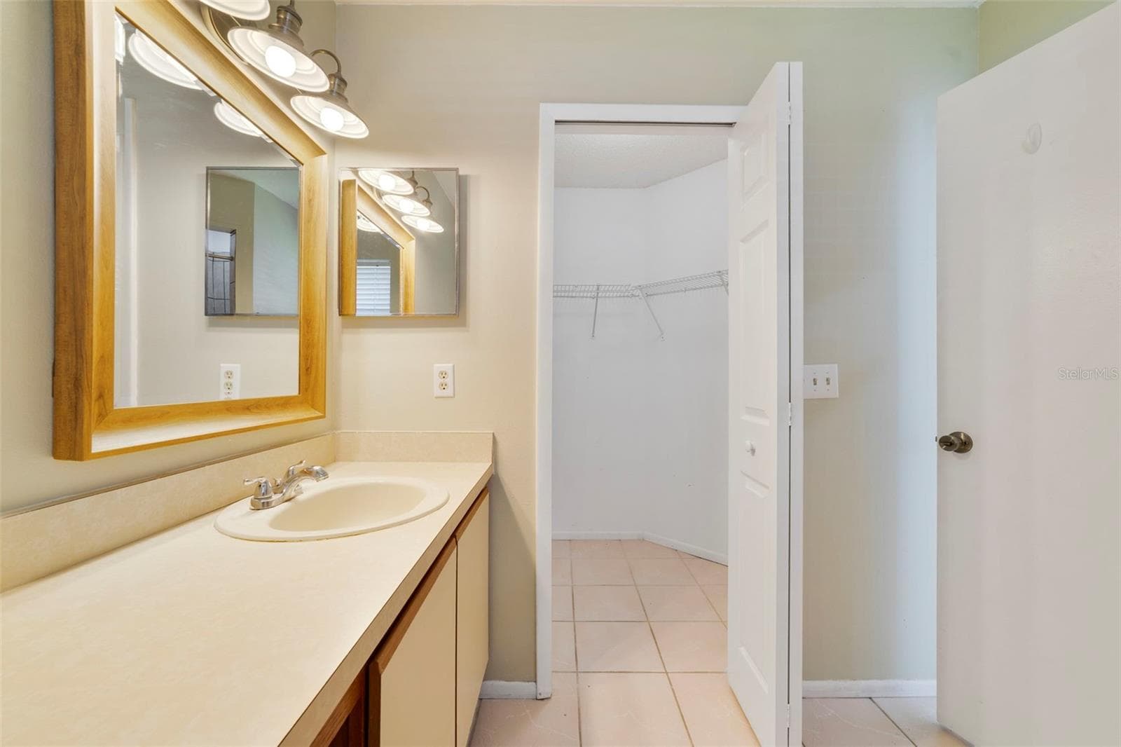 The Primary en-suite bath boasts a step-in shower, vanity with makeup space, and includes a LARGE WALK-IN CLOSET for convenient storage. - 713 MEADOWSIDE CT, ORLANDO