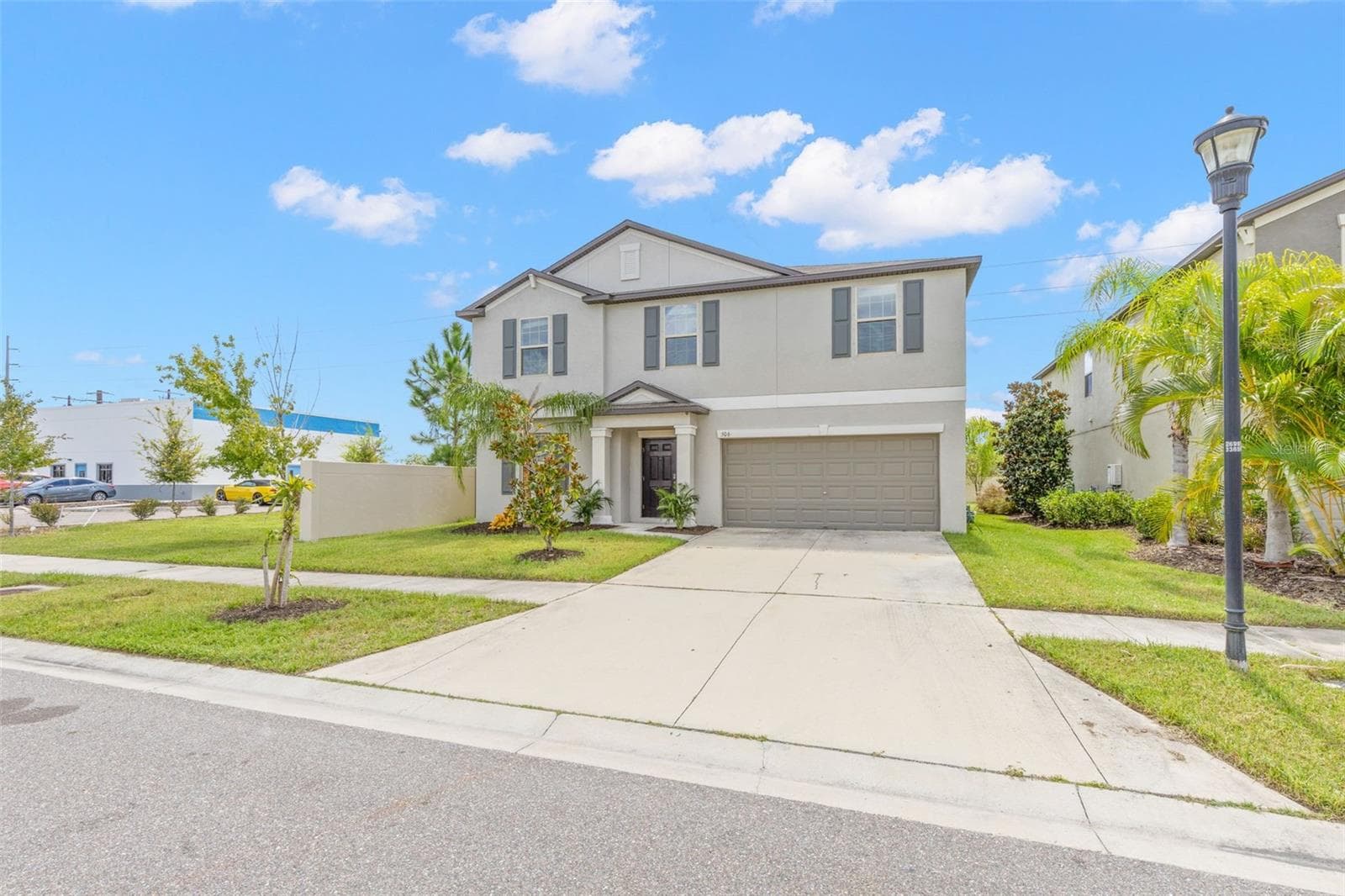 A wide driveway leads to the attached two-car garage, while the covered front entry, mature landscaping and clean stucco exterior give the 2022-built home a polished, easy-care first impression. - 5061 WHITE CHICORY DR, APOLLO BEACH