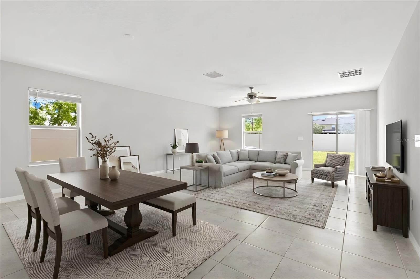 The great room offers plenty of space for both seating and dining, with fresh neutral paint, tile flooring and direct access to the backyard through sliding glass doors. - 5061 WHITE CHICORY DR, APOLLO BEACH