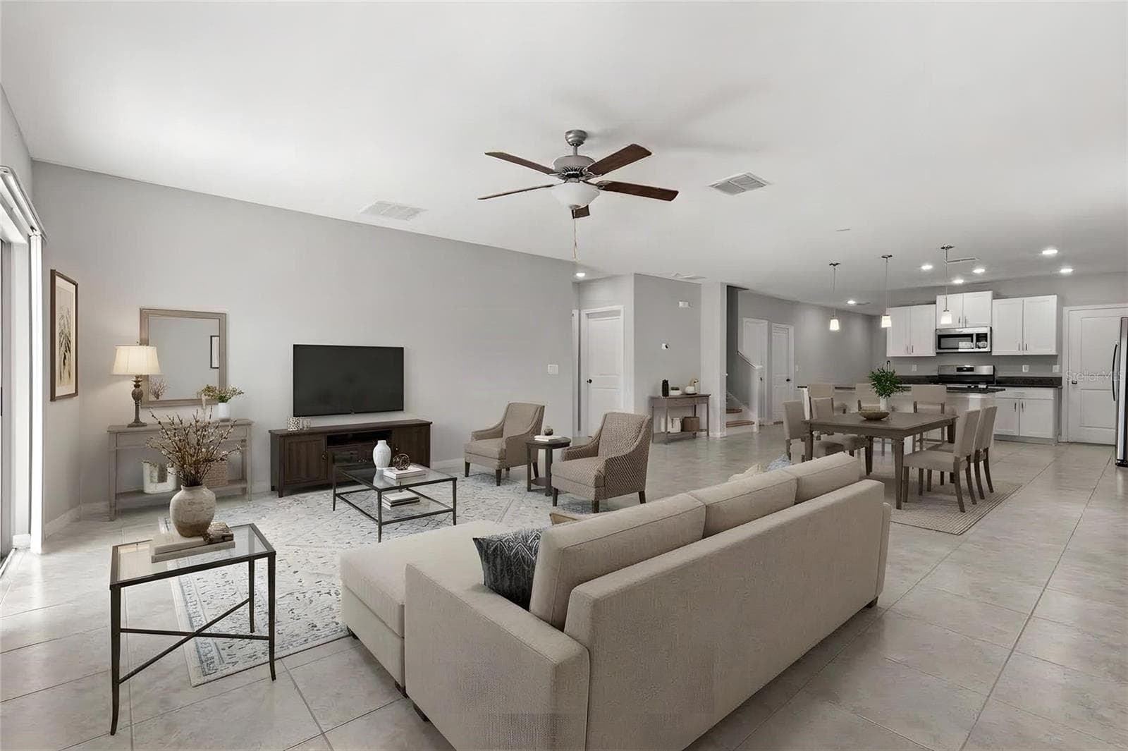 The great room offers plenty of space for both seating and dining, with fresh neutral paint, tile flooring and direct access to the backyard through sliding glass doors. - 5061 WHITE CHICORY DR, APOLLO BEACH
