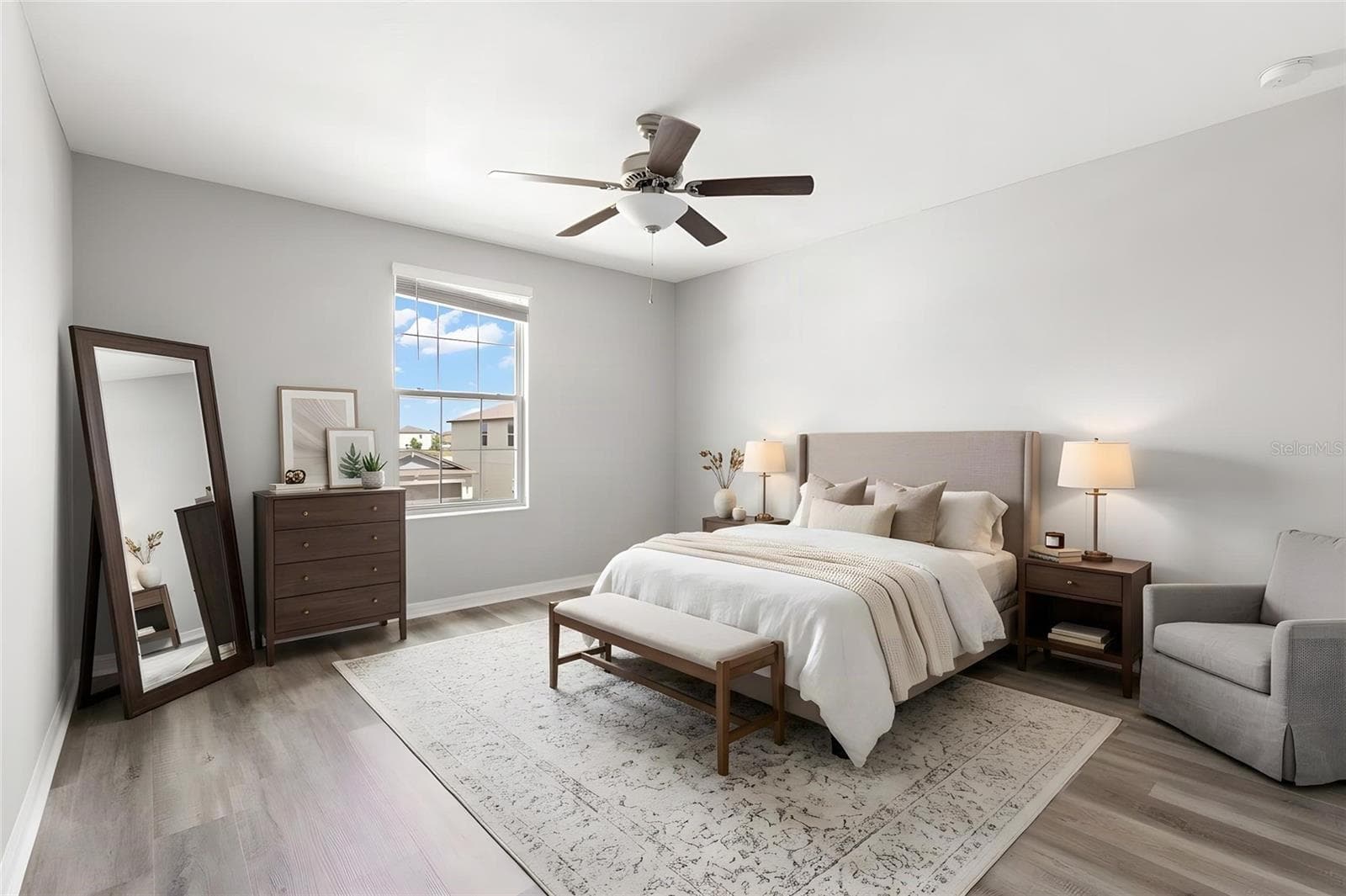 Bedroom 2 offers a comfortable footprint with newly replaced laminate flooring, fresh neutral paint, a ceiling fan and a large window bringing in natural light. - 5061 WHITE CHICORY DR, APOLLO BEACH